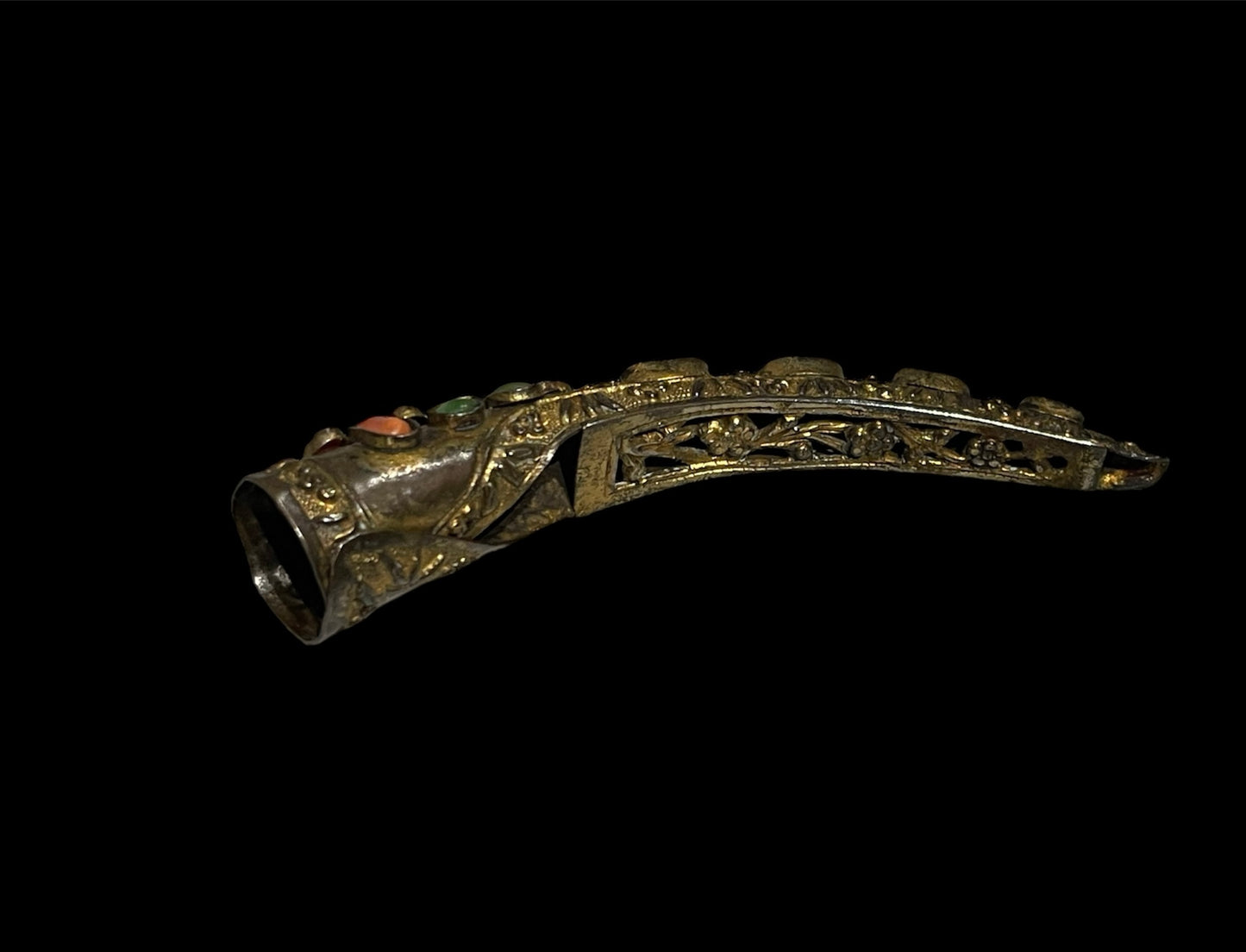 A vintage gilded silver nail cover with intricate carved work
