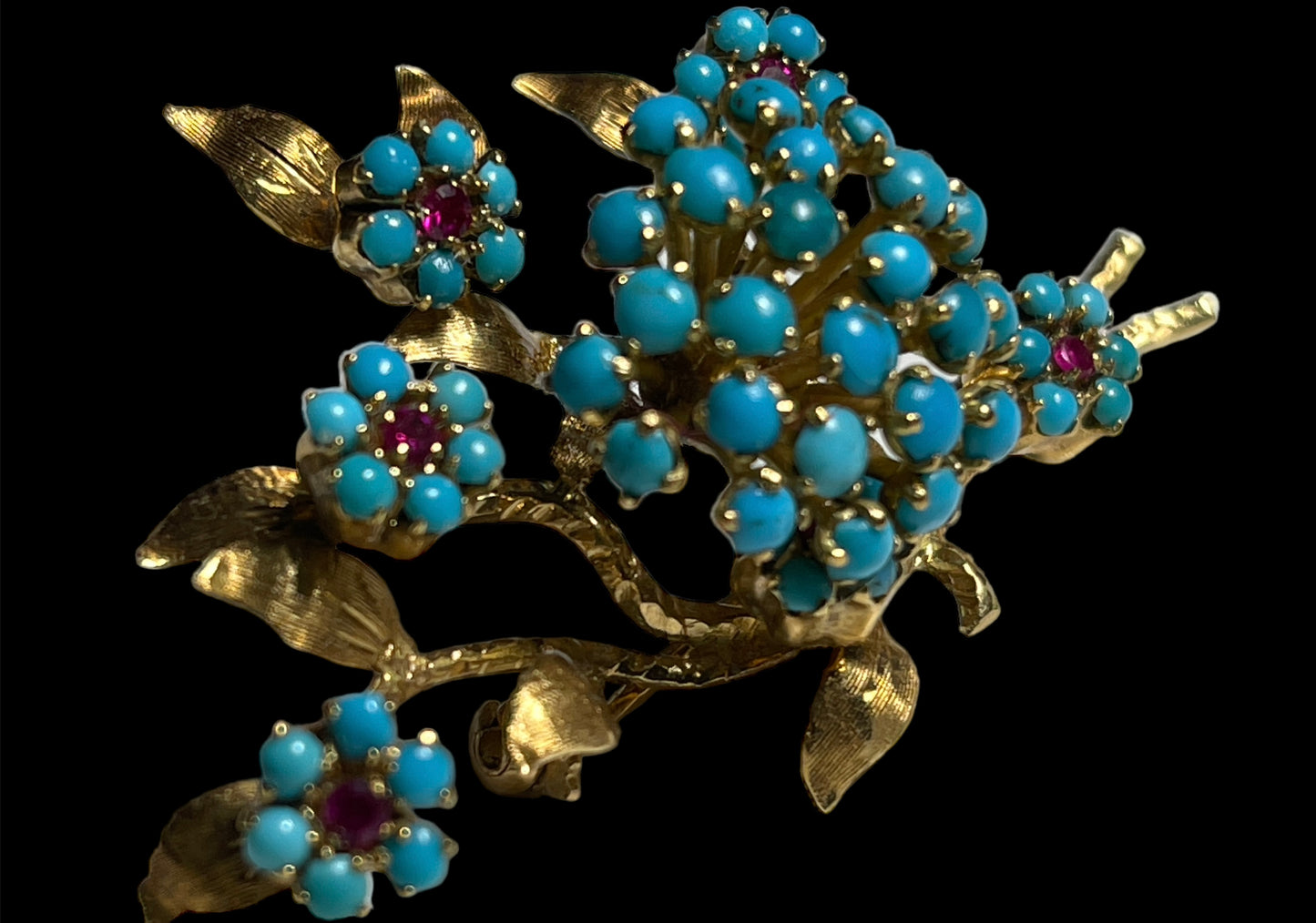 A 14k gold brooch with turquoise and ruby stones