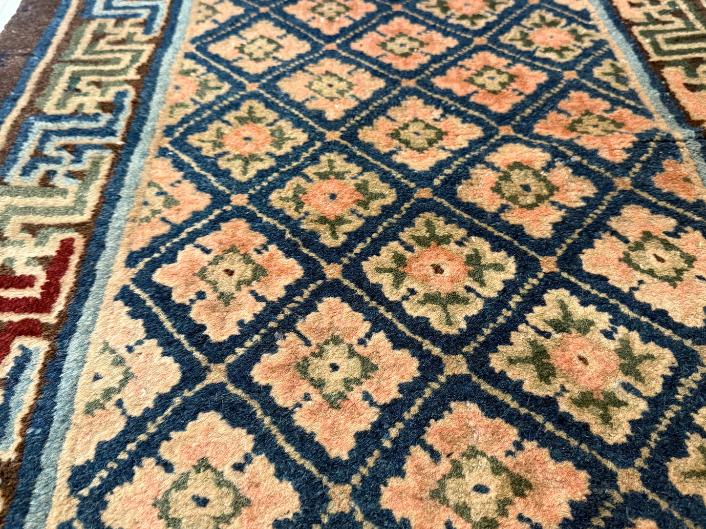 Antique rug with floral motifs arranged in a geometrical design