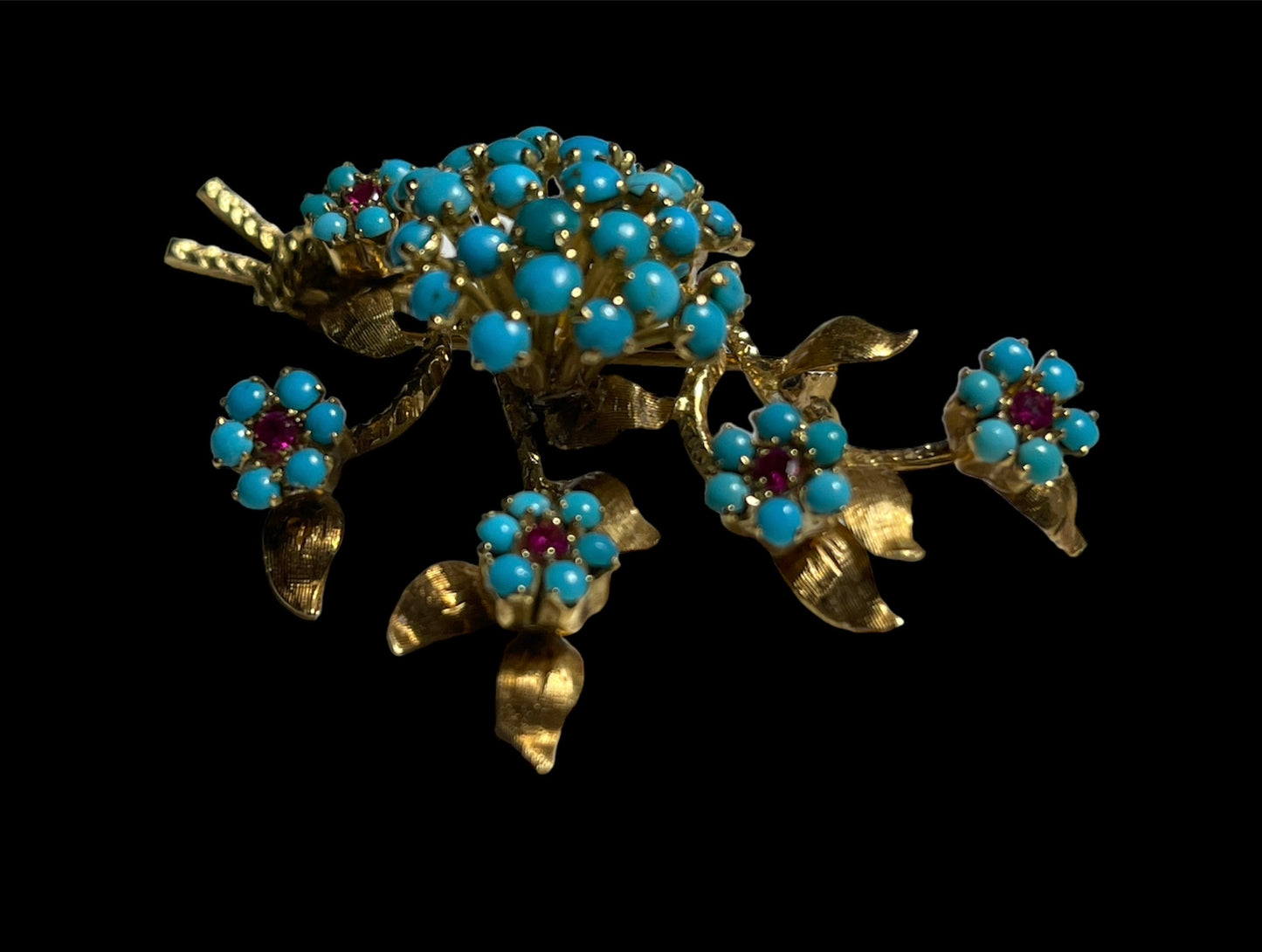 A 14k gold brooch with turquoise and ruby stones