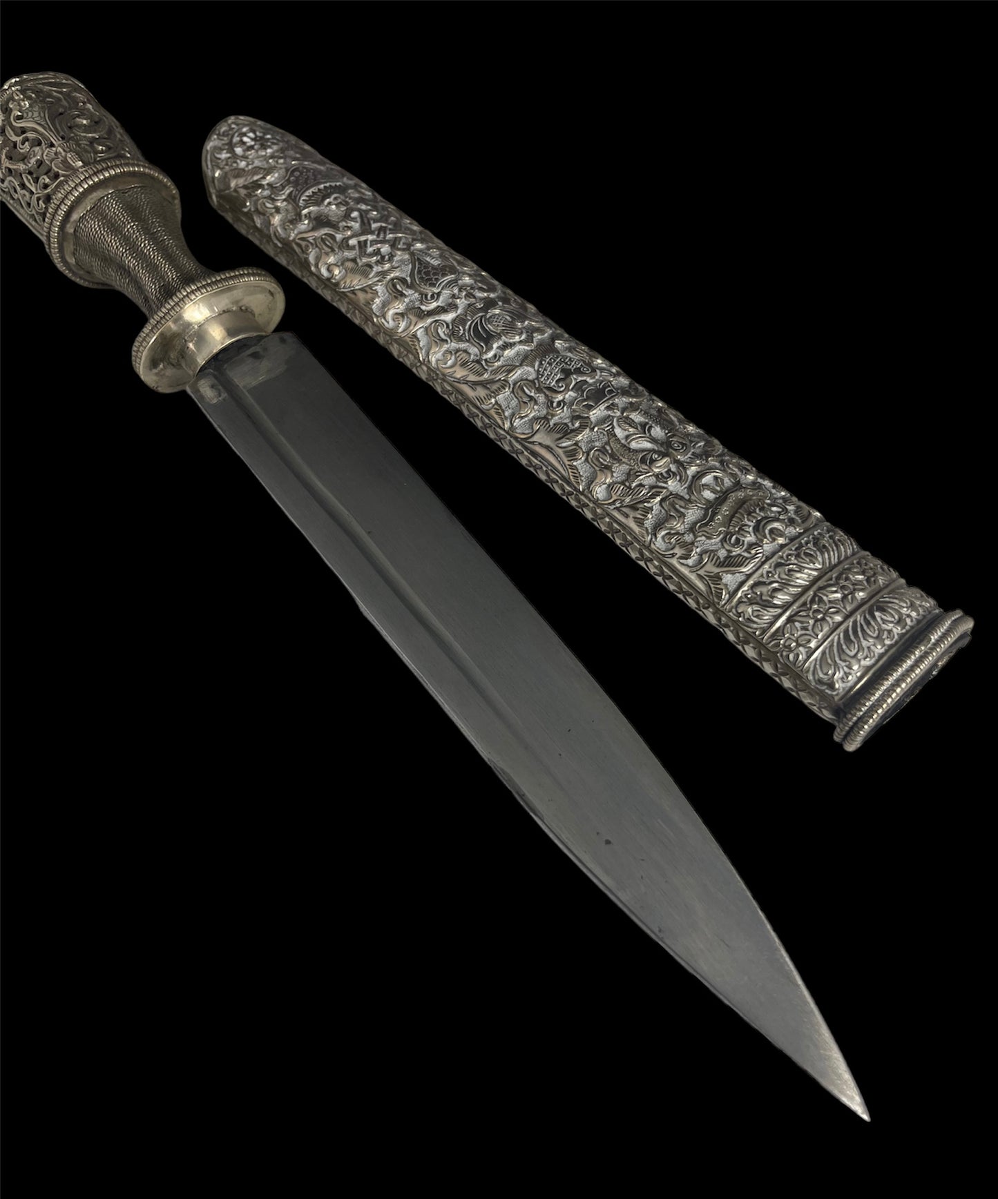 An antique Tibetan dagger with a carved silver sheath