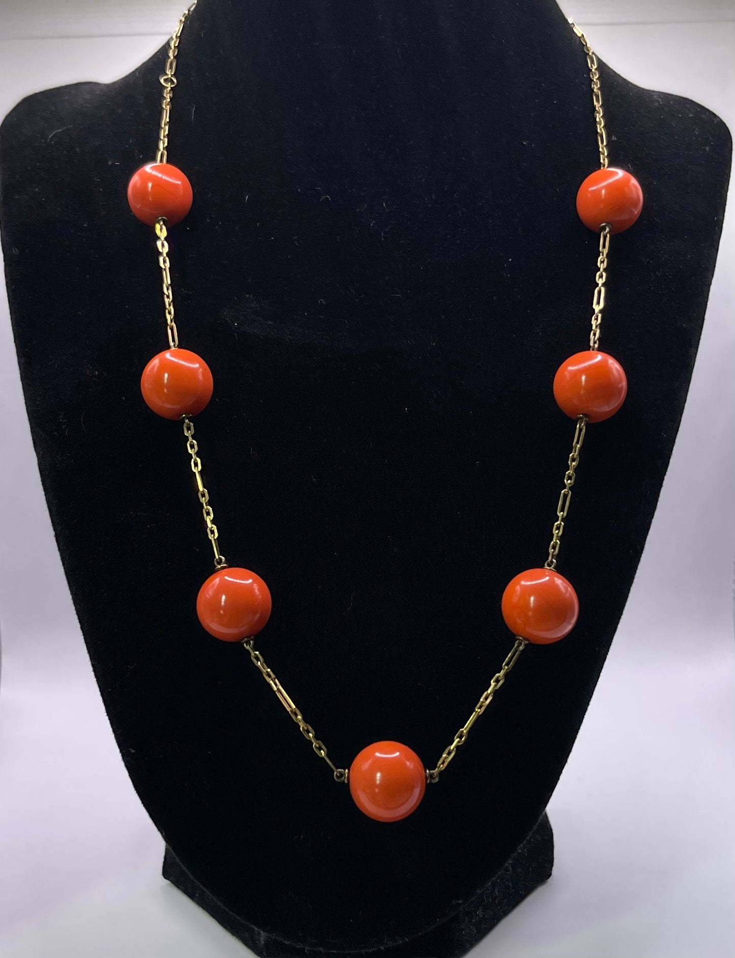 A necklace with coral beads on a 14kt chain