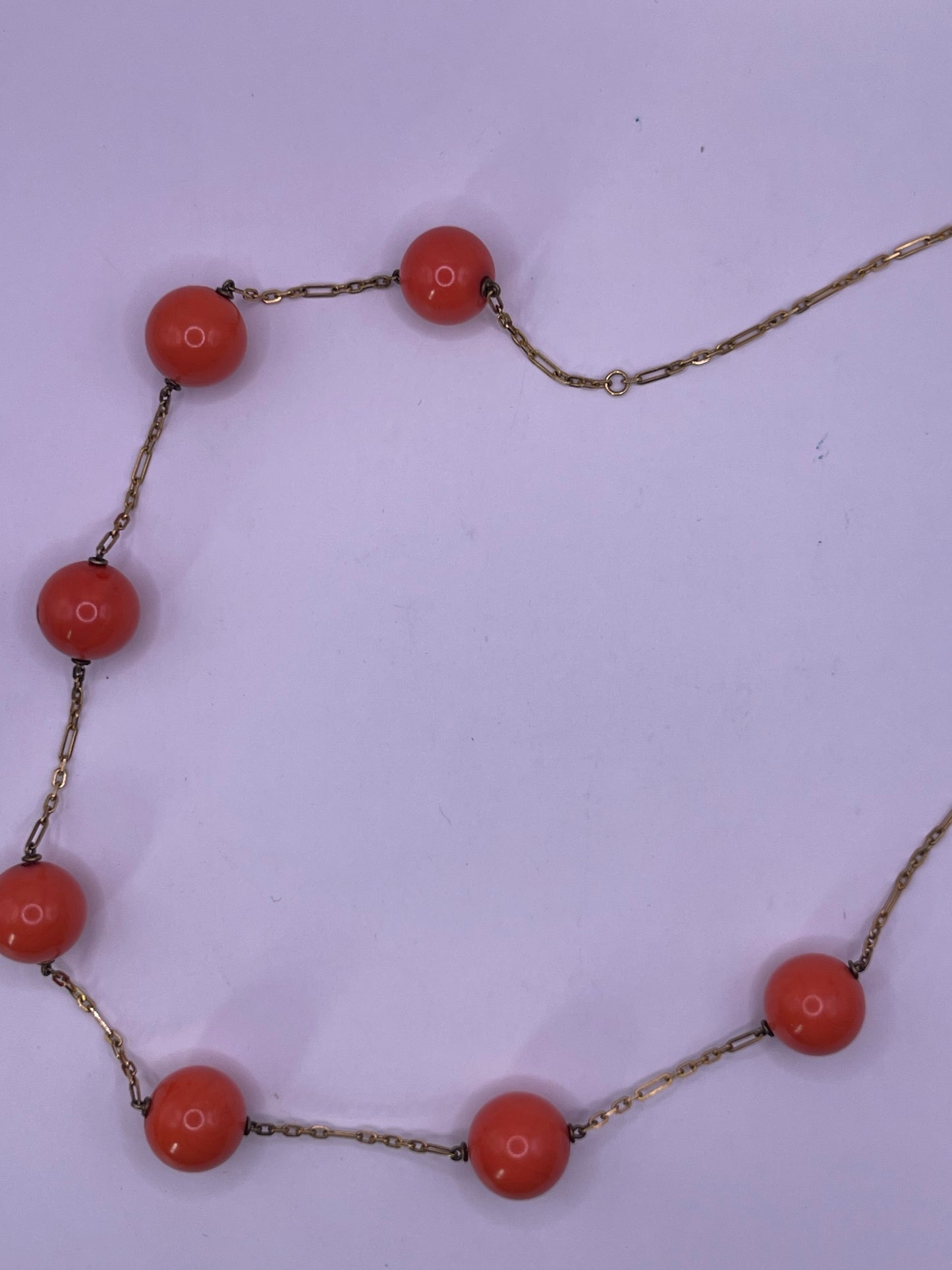 A necklace with coral beads on a 14kt chain
