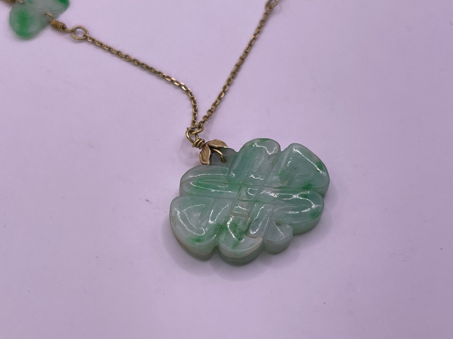 A vintage Art Deco style necklace with an antique apple green jade carved plaque and smaller plaques on 14kt chain