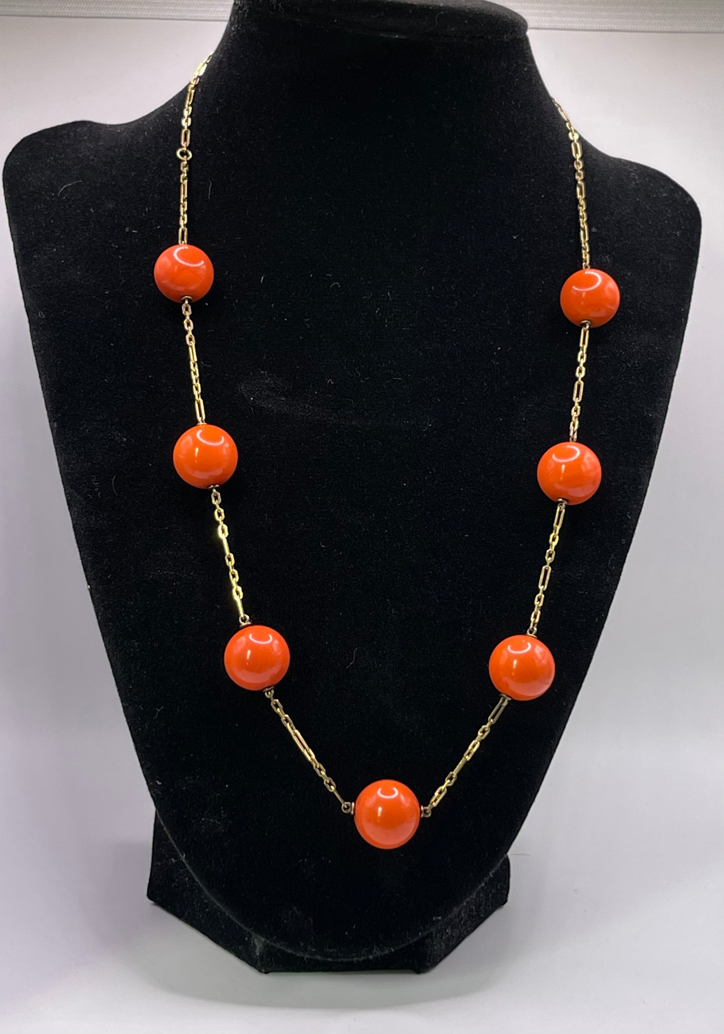 A necklace with coral beads on a 14kt chain