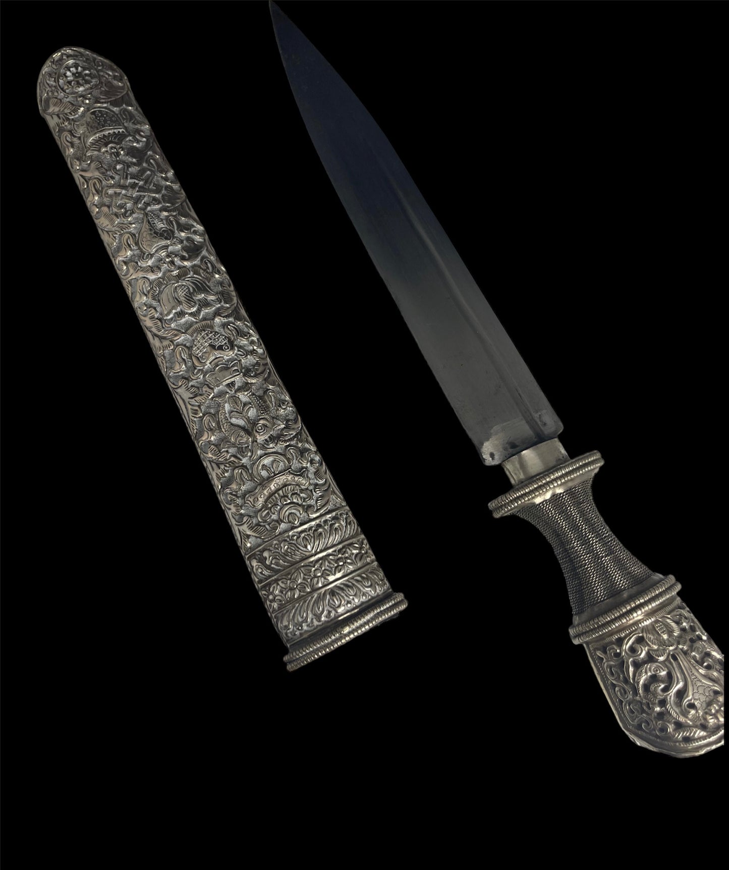 An antique Tibetan dagger with a carved silver sheath
