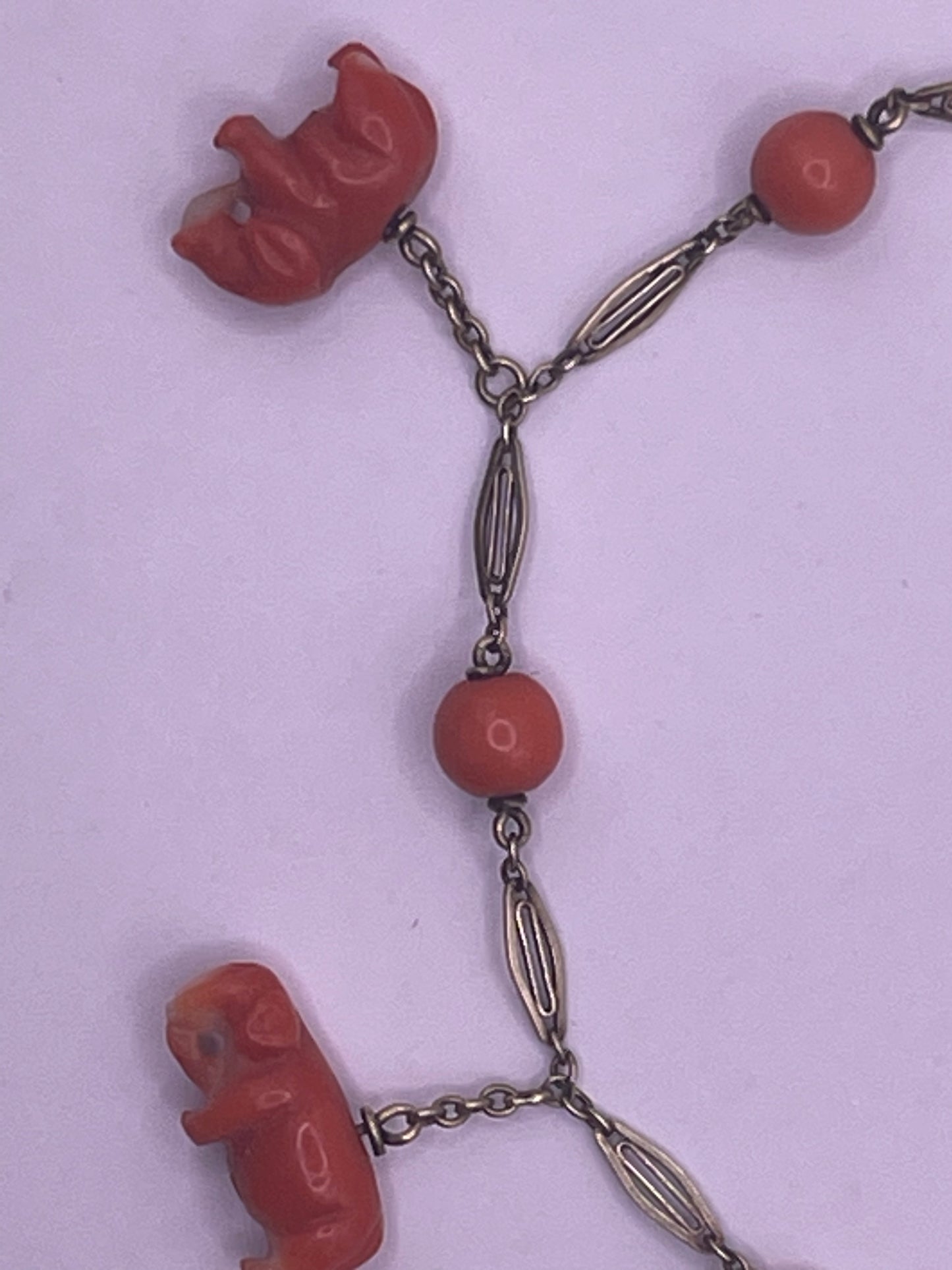 An antique coral bracelet with coral beads and carved coral elephant charms