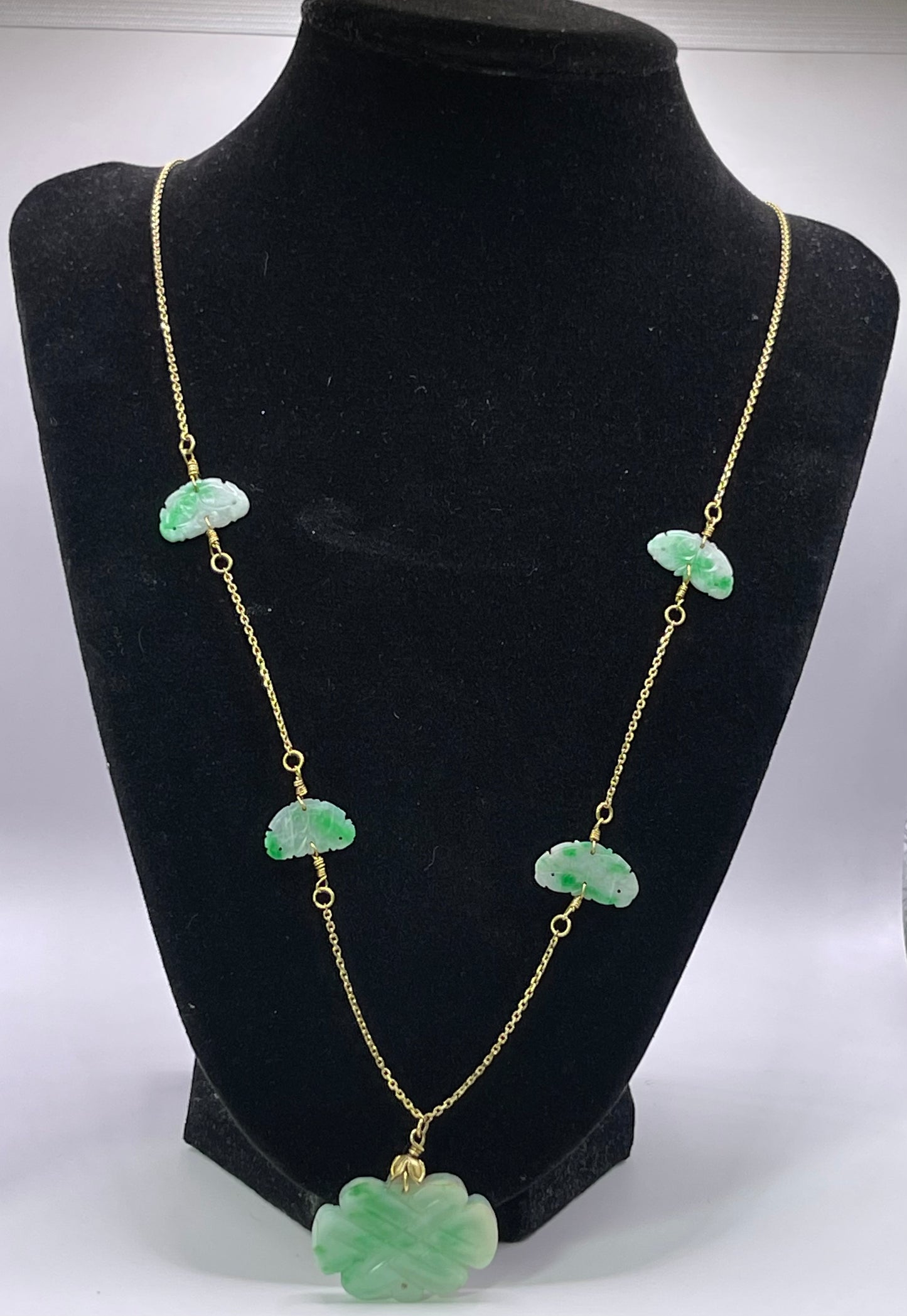 A vintage Art Deco style necklace with an antique apple green jade carved plaque and smaller plaques on 14kt chain