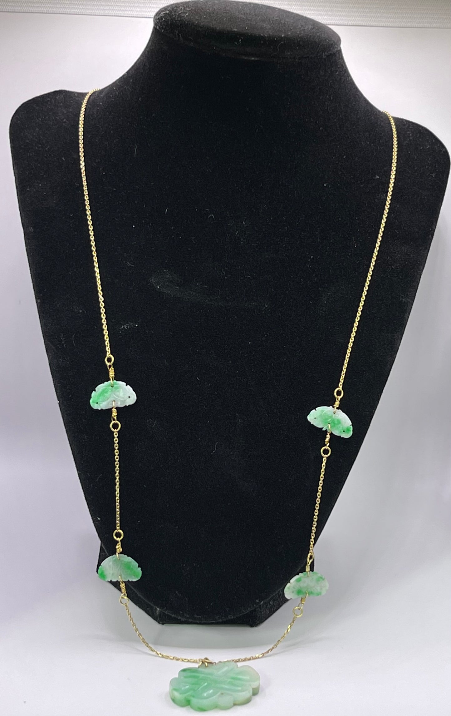 A vintage Art Deco style necklace with an antique apple green jade carved plaque and smaller plaques on 14kt chain