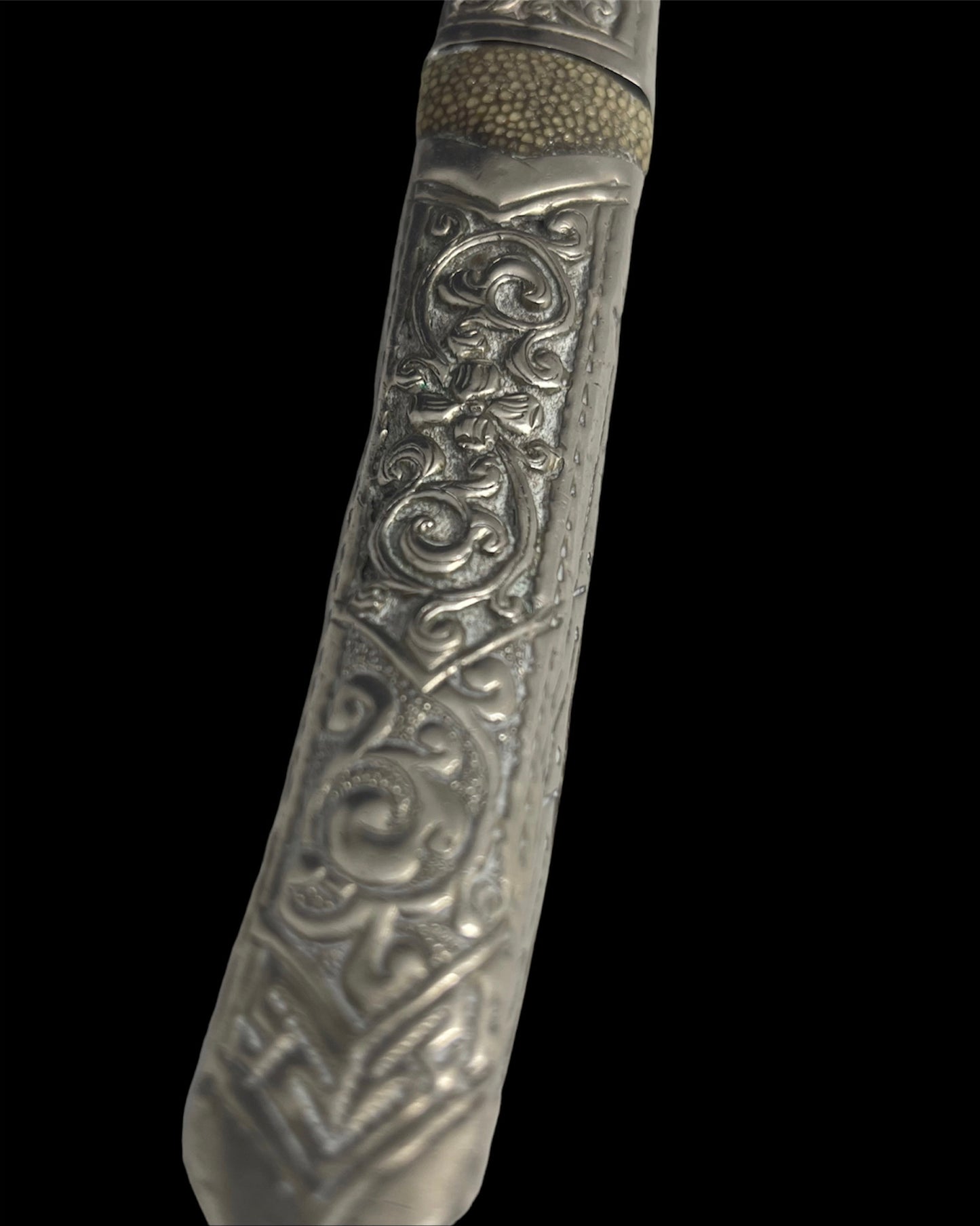 An antique Tibetan dagger with a carved silver sheath