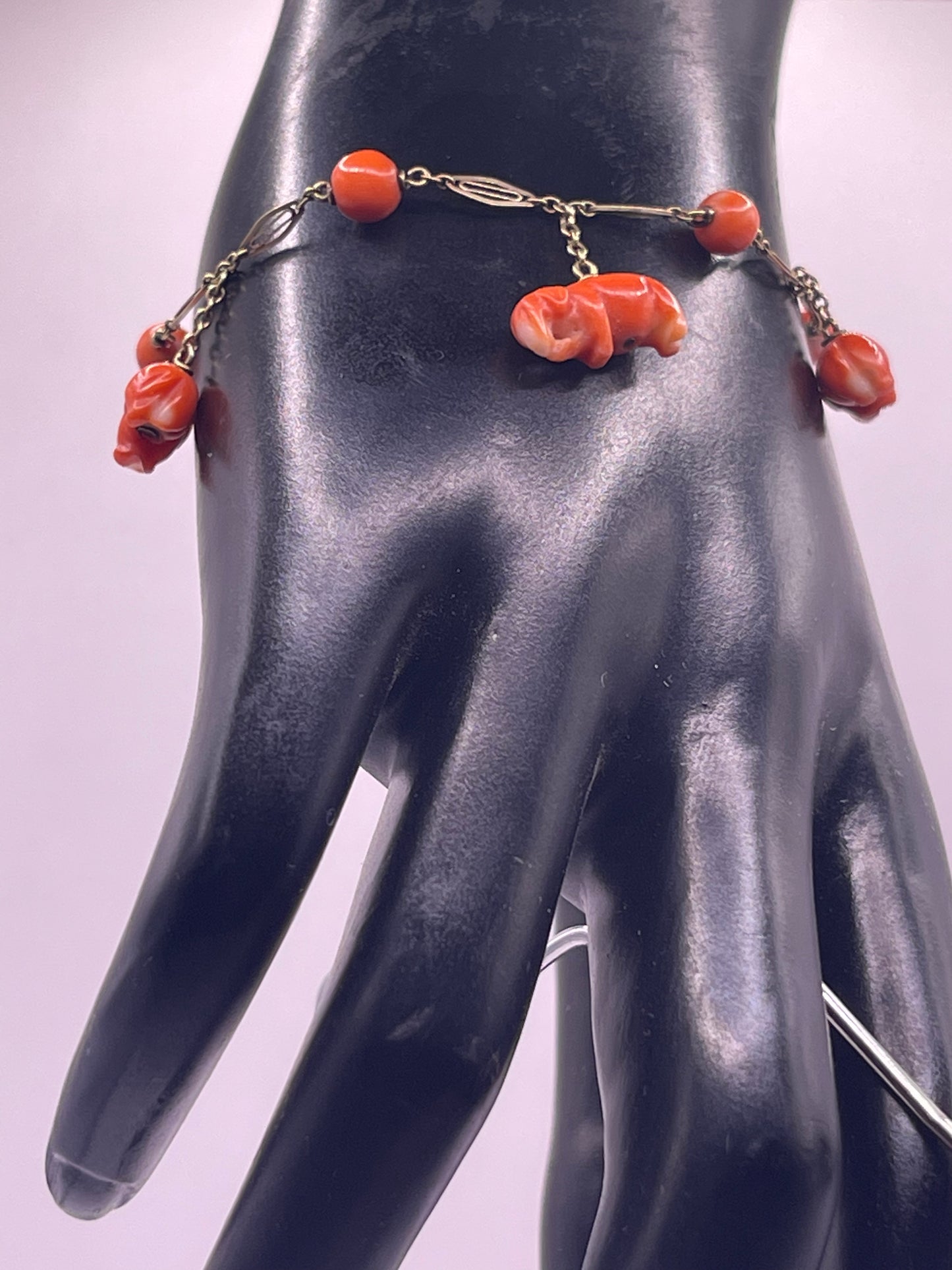 An antique coral bracelet with coral beads and carved coral elephant charms