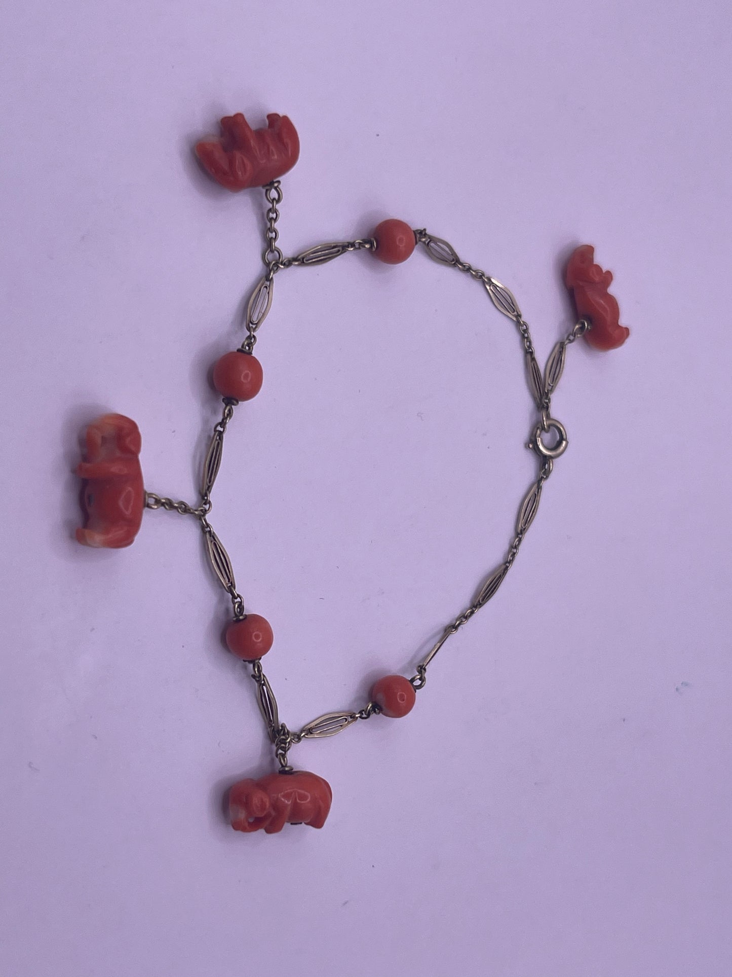 An antique coral bracelet with coral beads and carved coral elephant charms