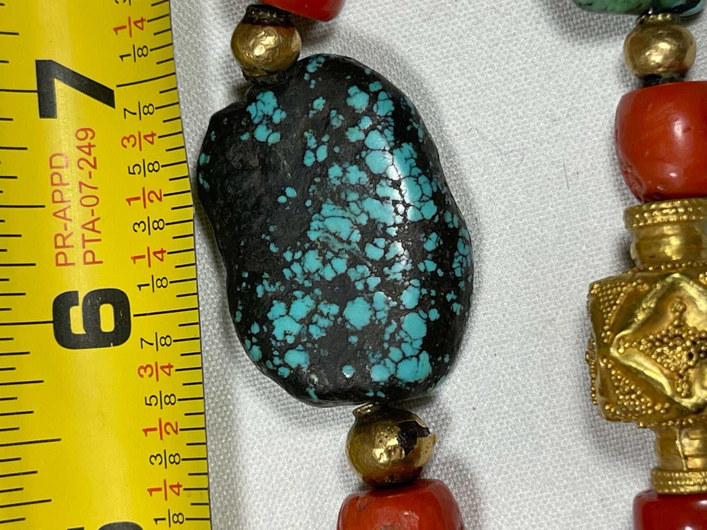 A necklace with antique Tibetan turquoise beads, coral beads and gold beads