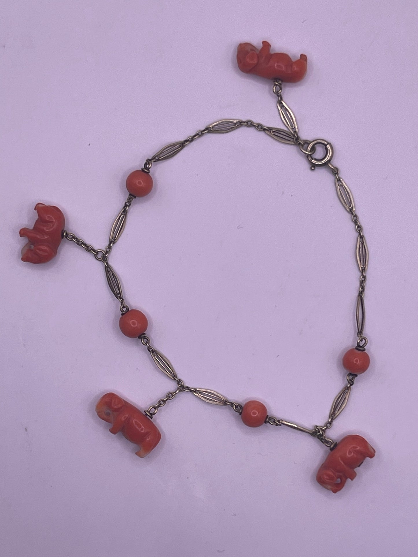An antique coral bracelet with coral beads and carved coral elephant charms