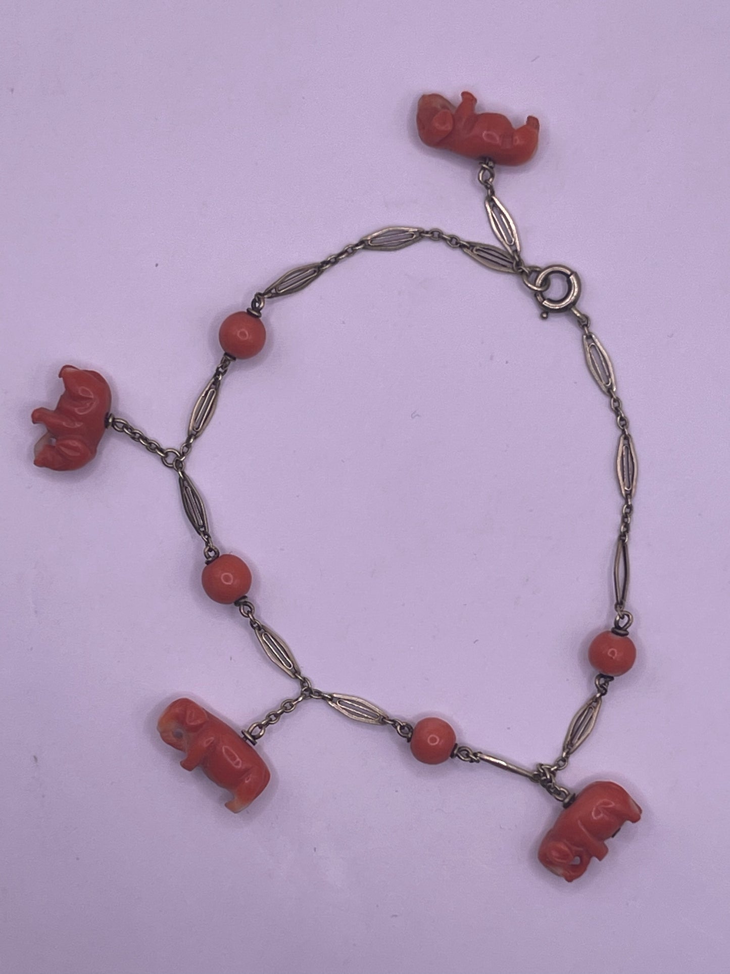 An antique coral bracelet with coral beads and carved coral elephant charms