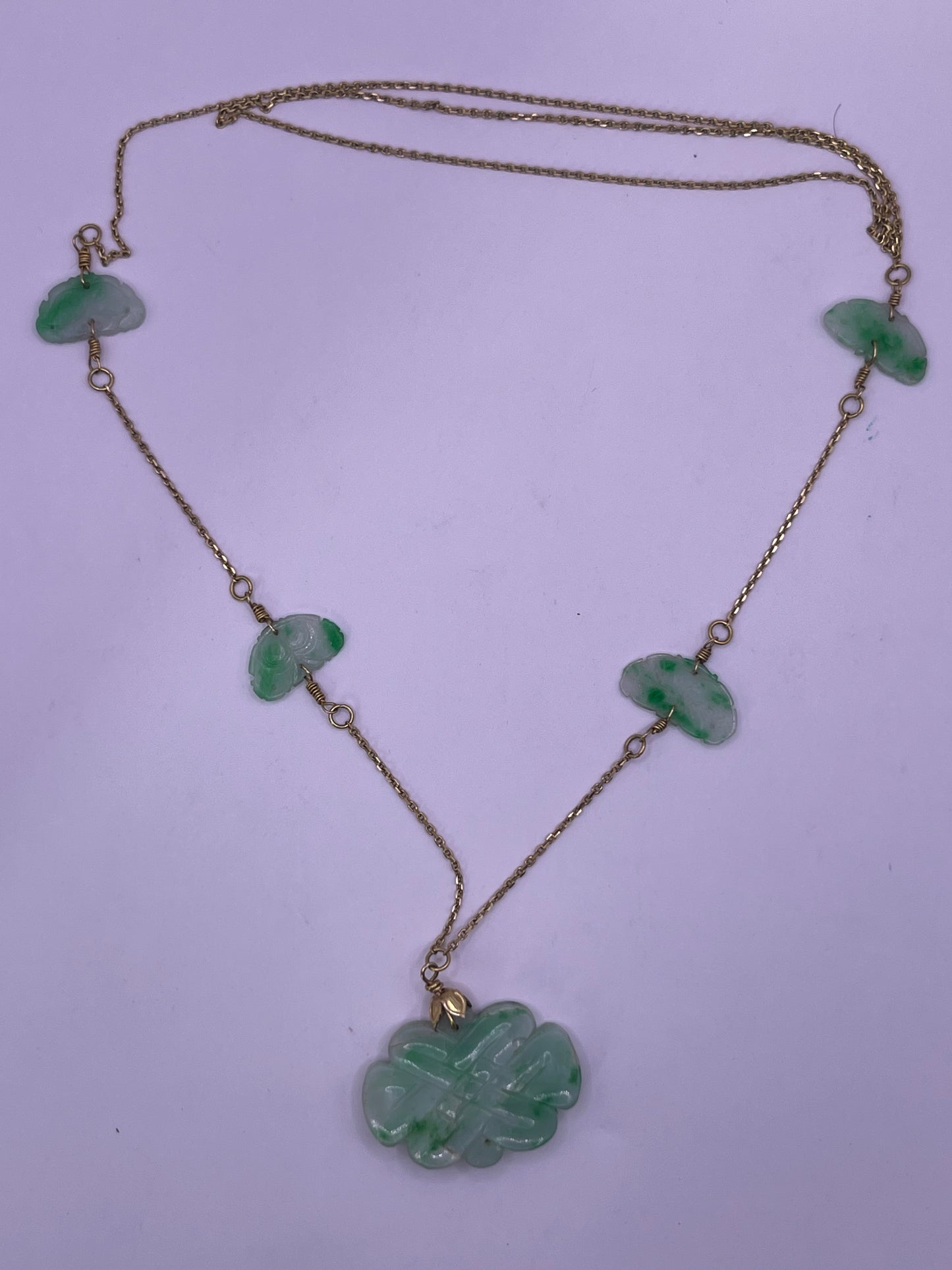 A vintage Art Deco style necklace with an antique apple green jade carved plaque and smaller plaques on 14kt chain