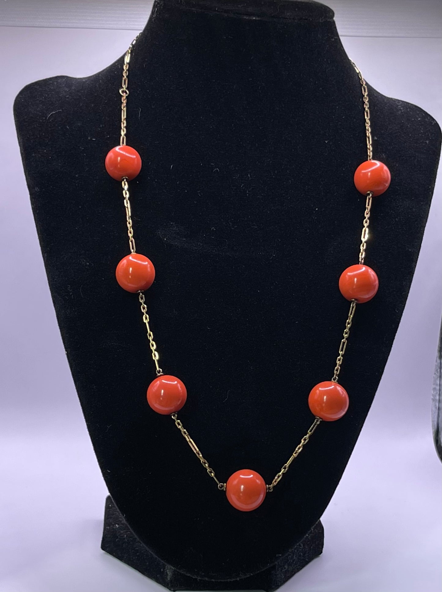 A necklace with coral beads on a 14kt chain