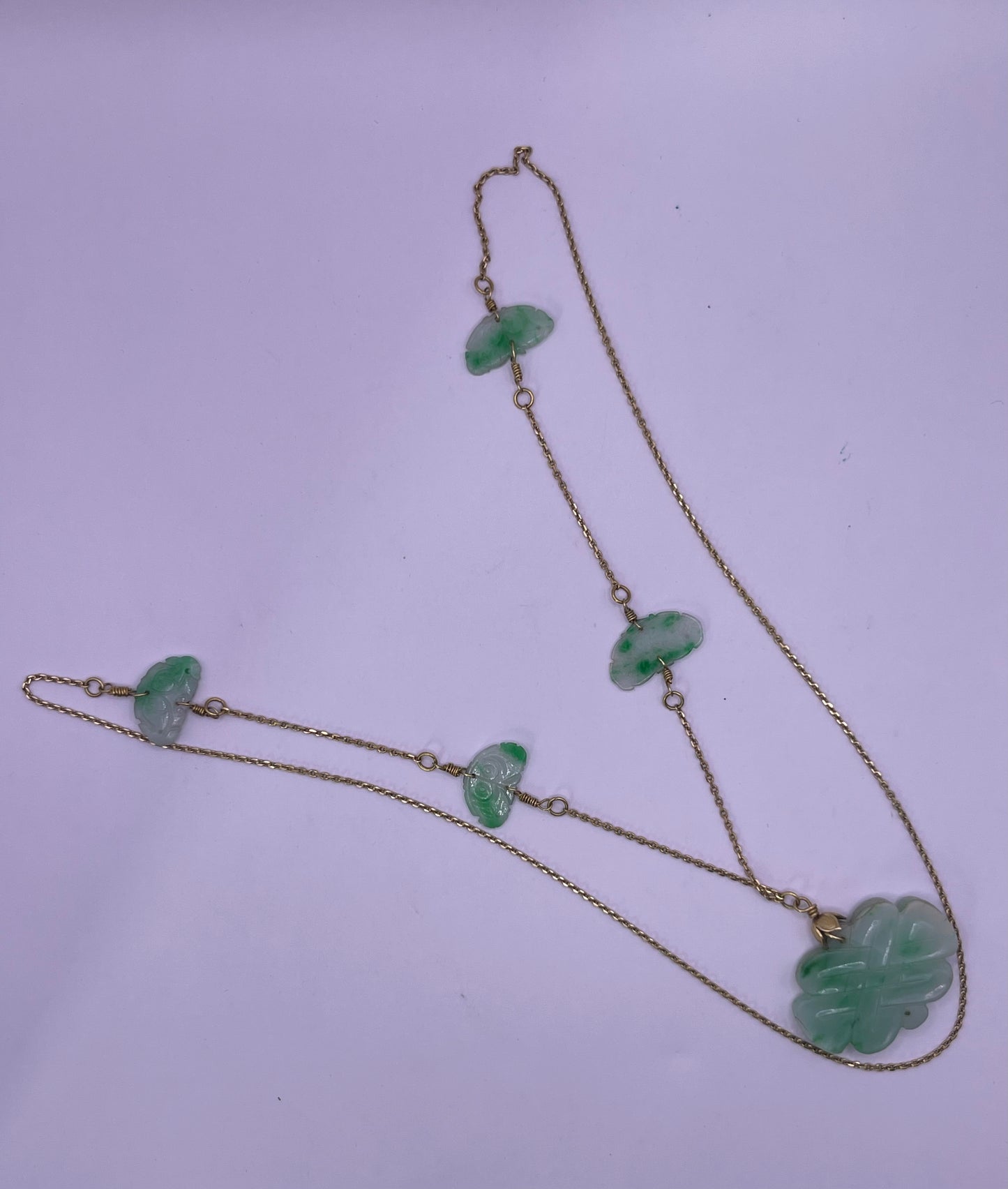 A vintage Art Deco style necklace with an antique apple green jade carved plaque and smaller plaques on 14kt chain