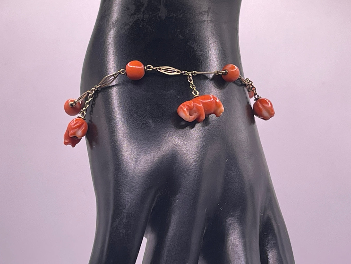 An antique coral bracelet with coral beads and carved coral elephant charms