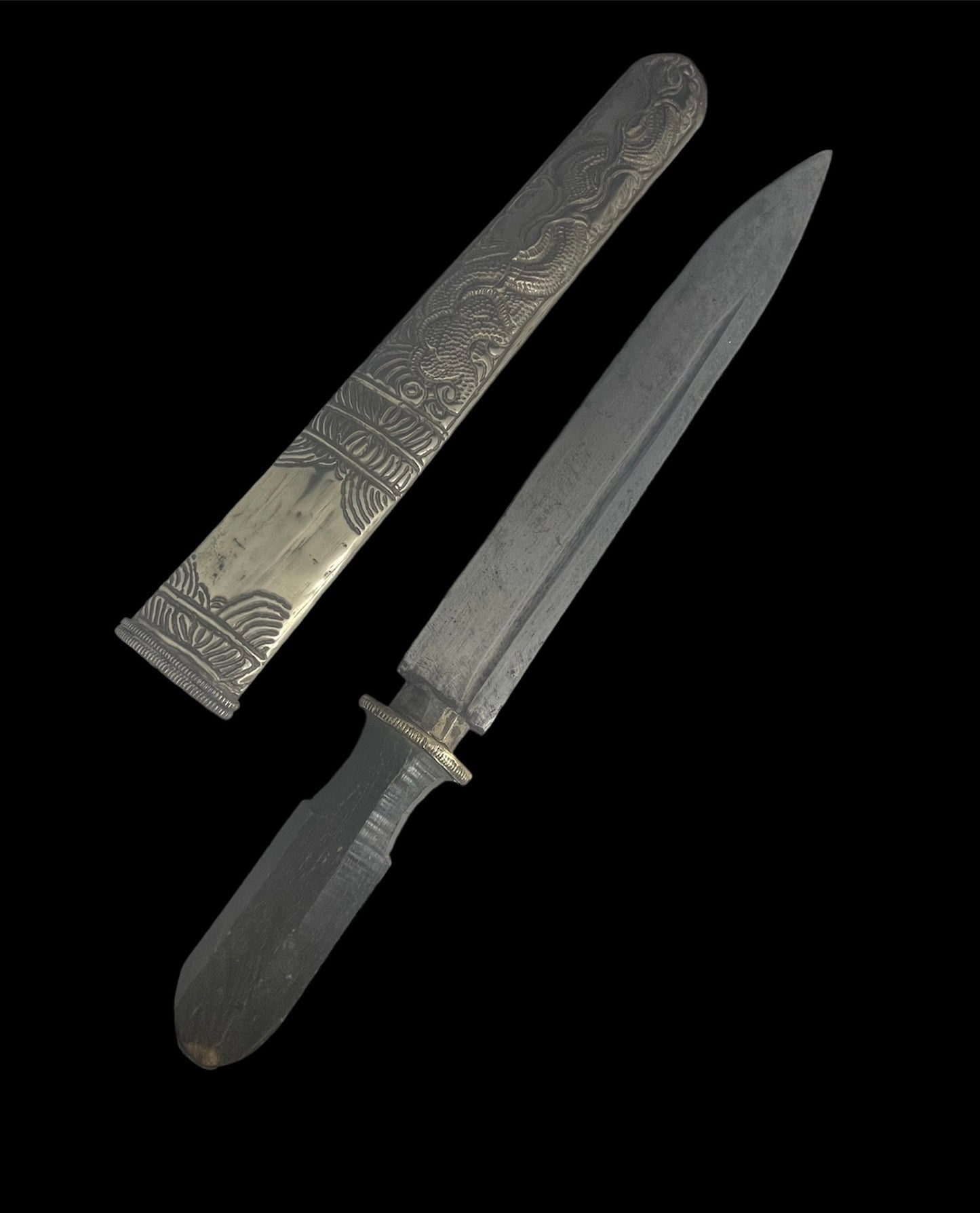 An antique Tibetan dagger with a carved silver sheath