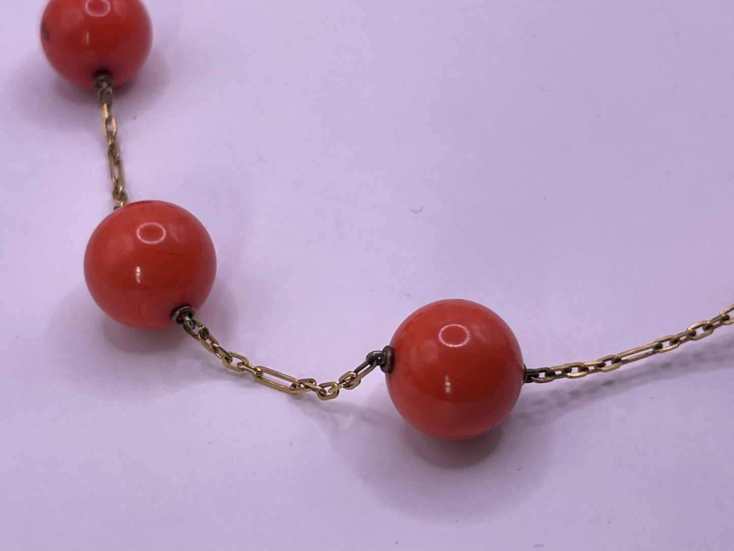 A necklace with coral beads on a 14kt chain