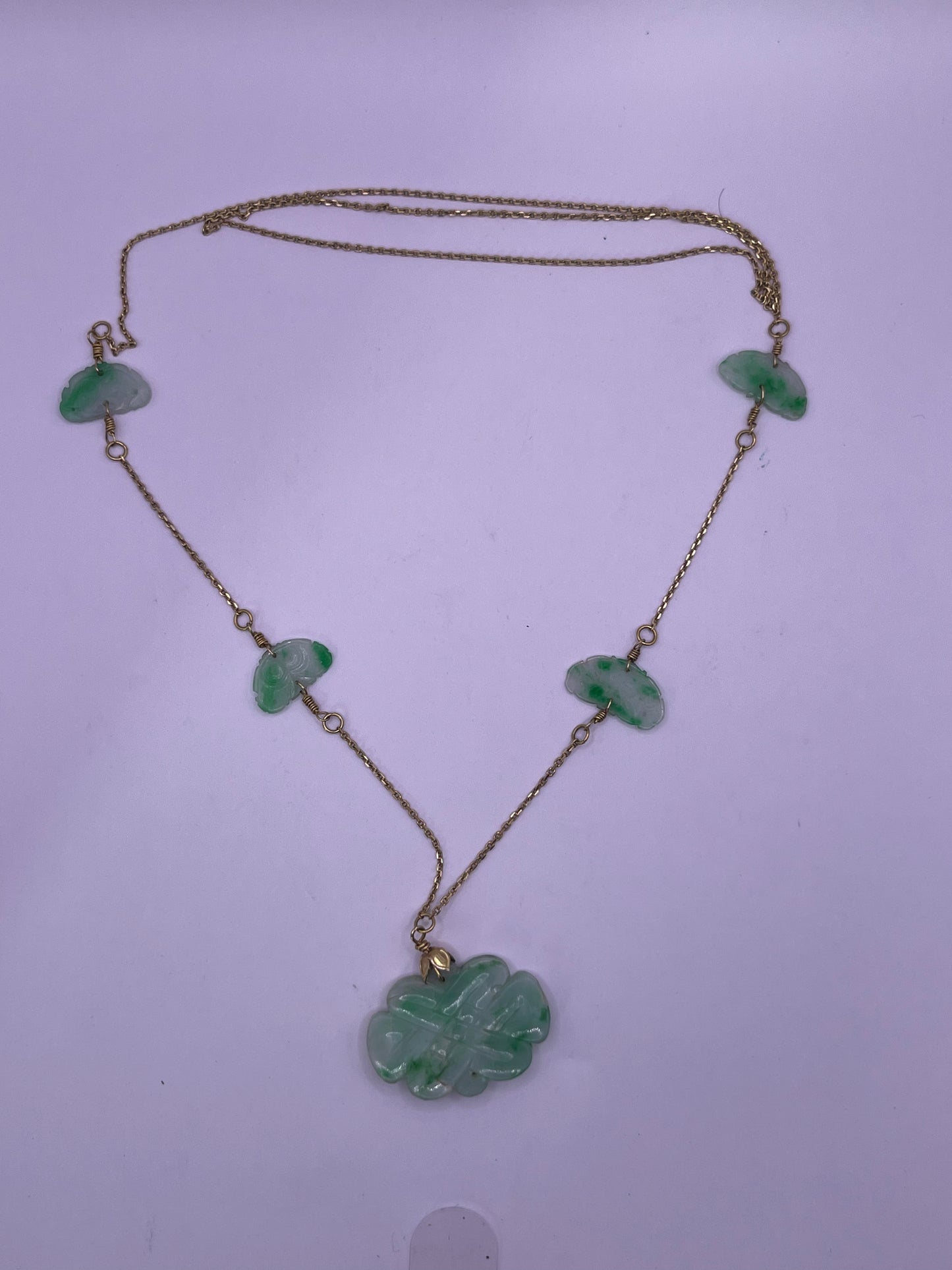 A vintage Art Deco style necklace with an antique apple green jade carved plaque and smaller plaques on 14kt chain