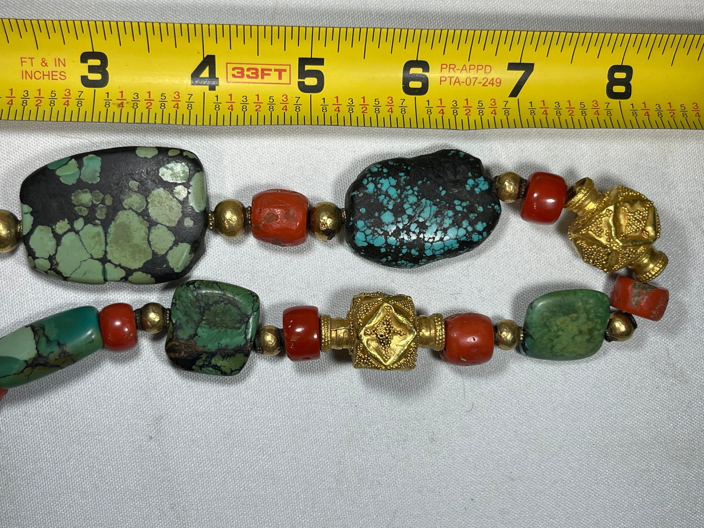 A necklace with antique Tibetan turquoise beads, coral beads and gold beads