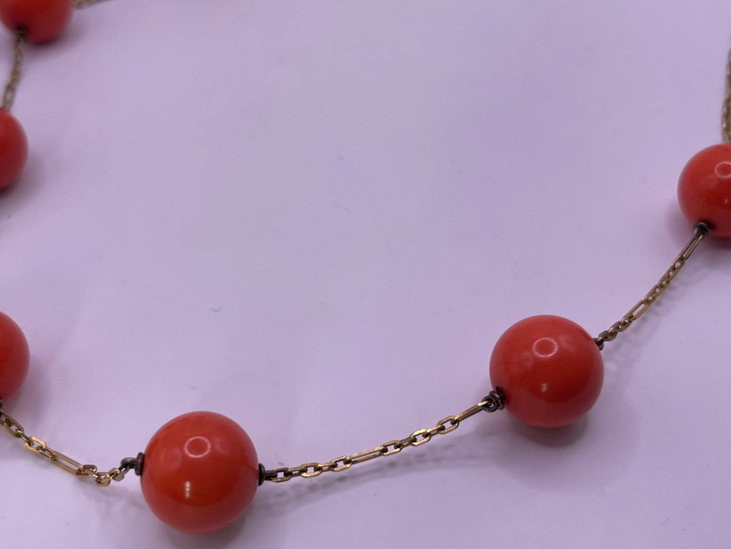 A necklace with coral beads on a 14kt chain
