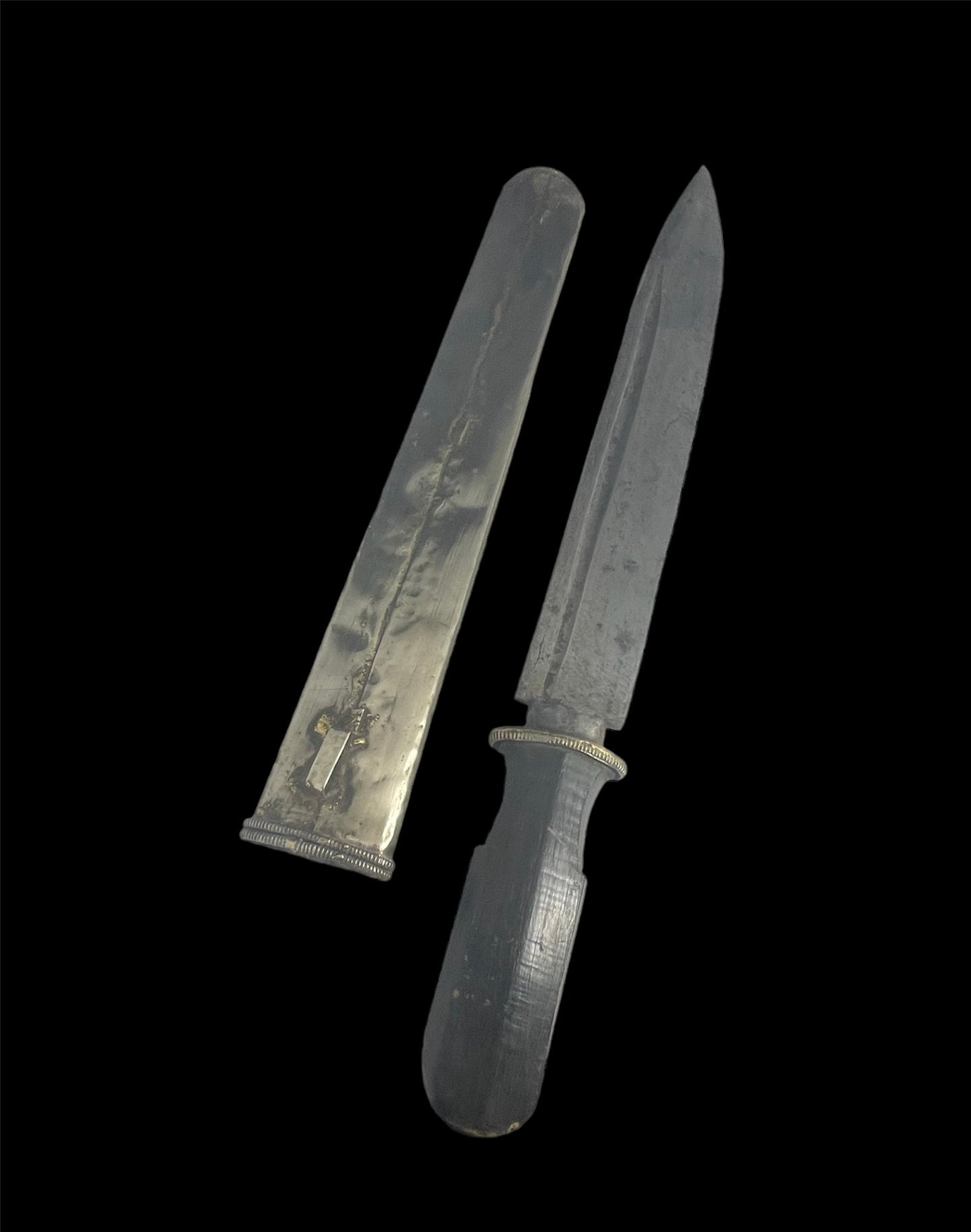 An antique Tibetan dagger with a carved silver sheath