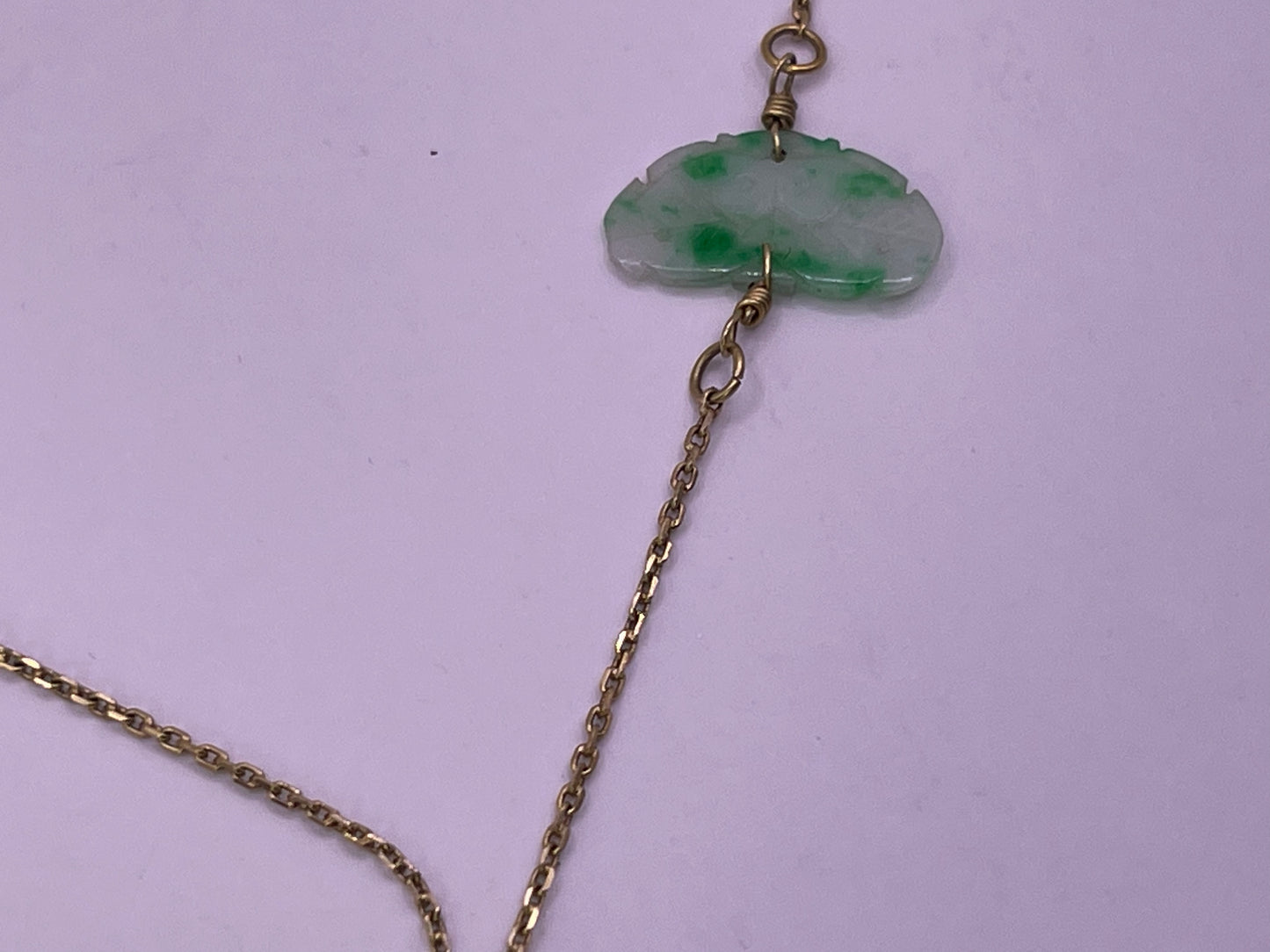 A vintage Art Deco style necklace with an antique apple green jade carved plaque and smaller plaques on 14kt chain