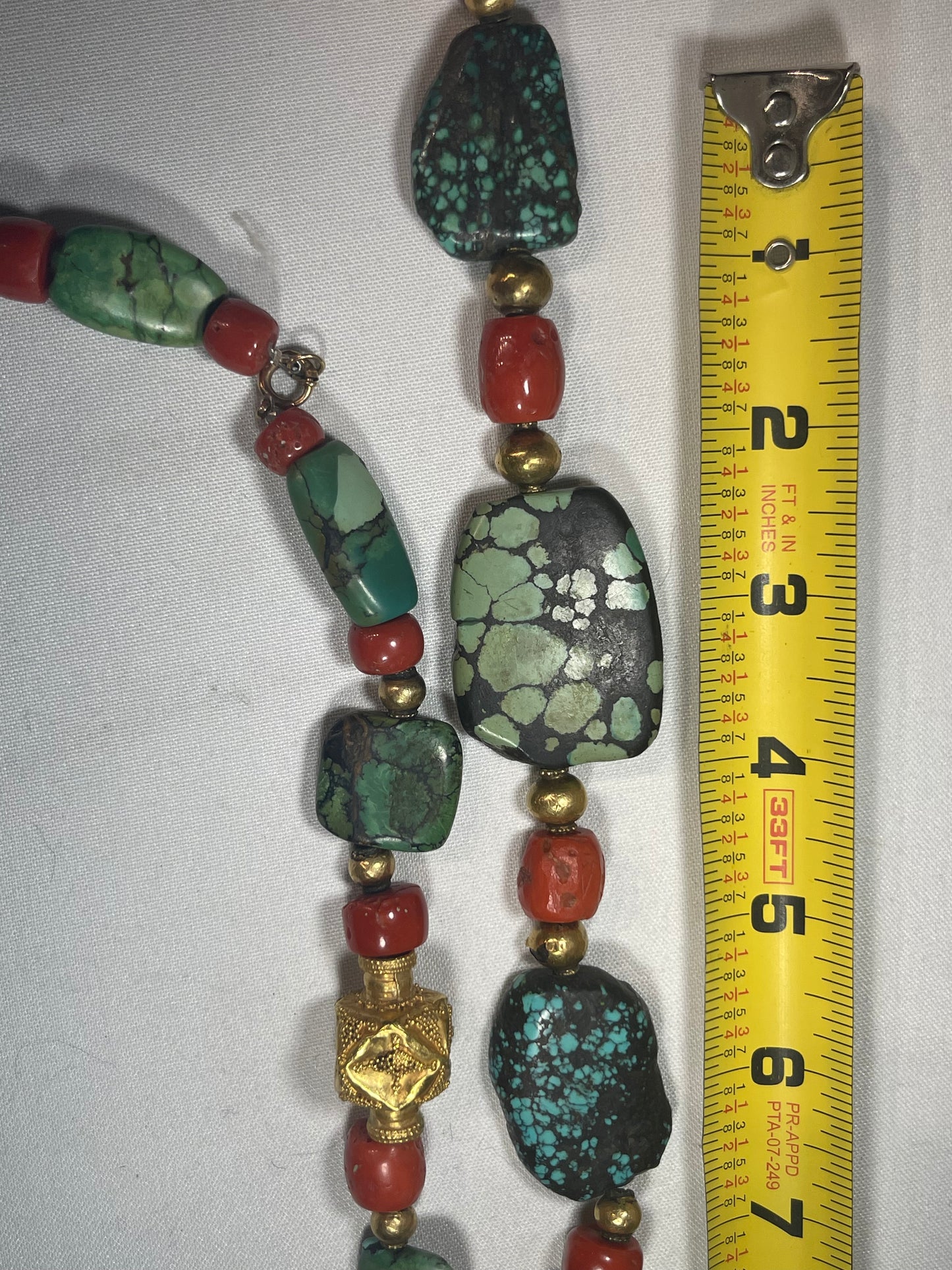 A necklace with antique Tibetan turquoise beads, coral beads and gold beads