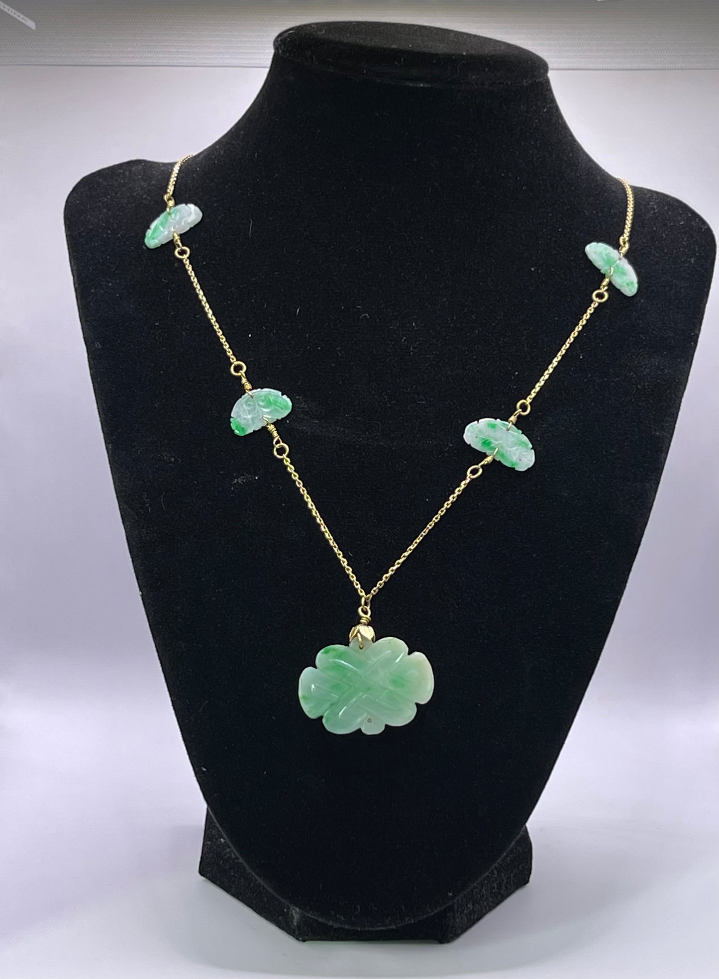 A vintage Art Deco style necklace with an antique apple green jade carved plaque and smaller plaques on 14kt chain