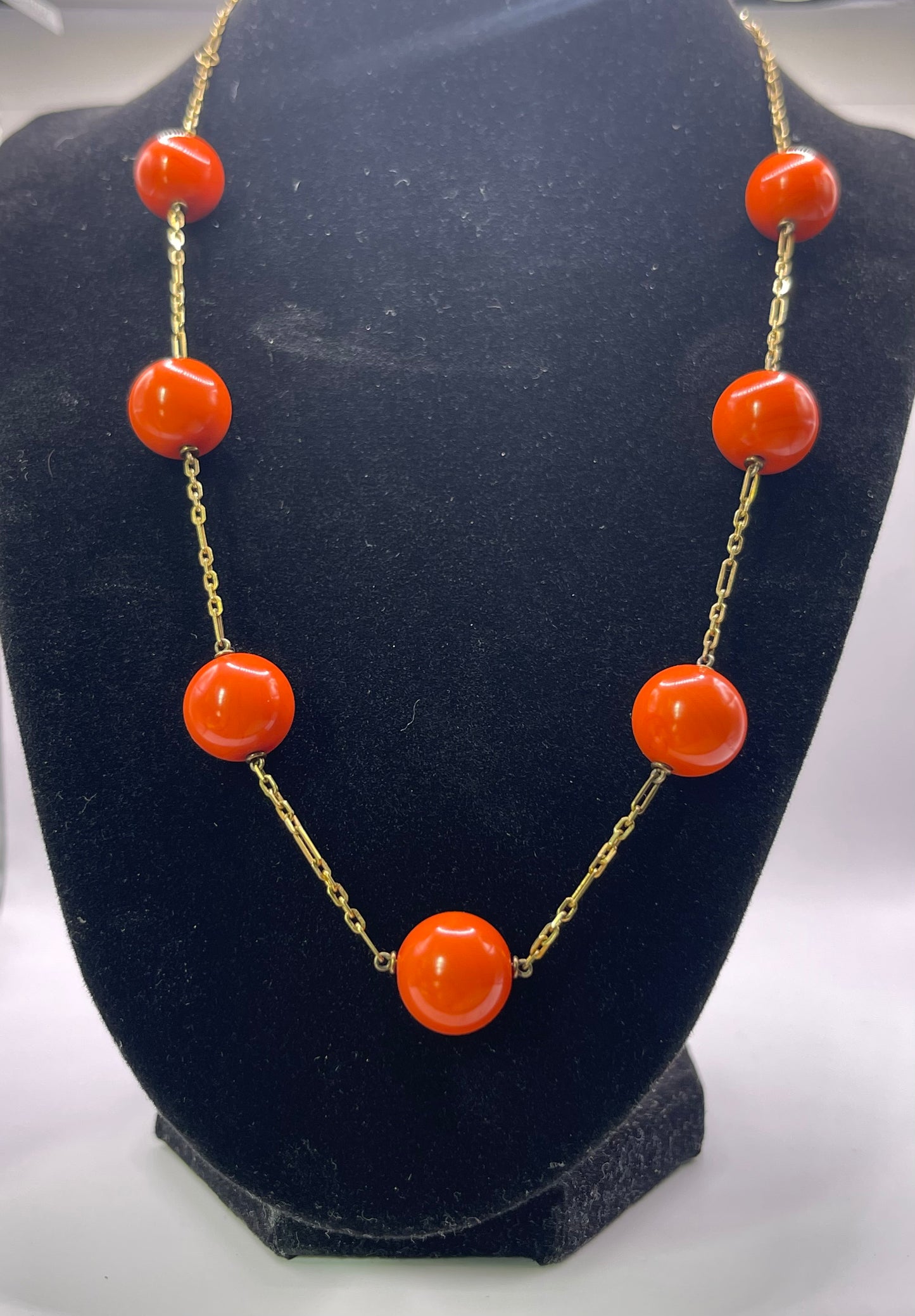 A necklace with coral beads on a 14kt chain