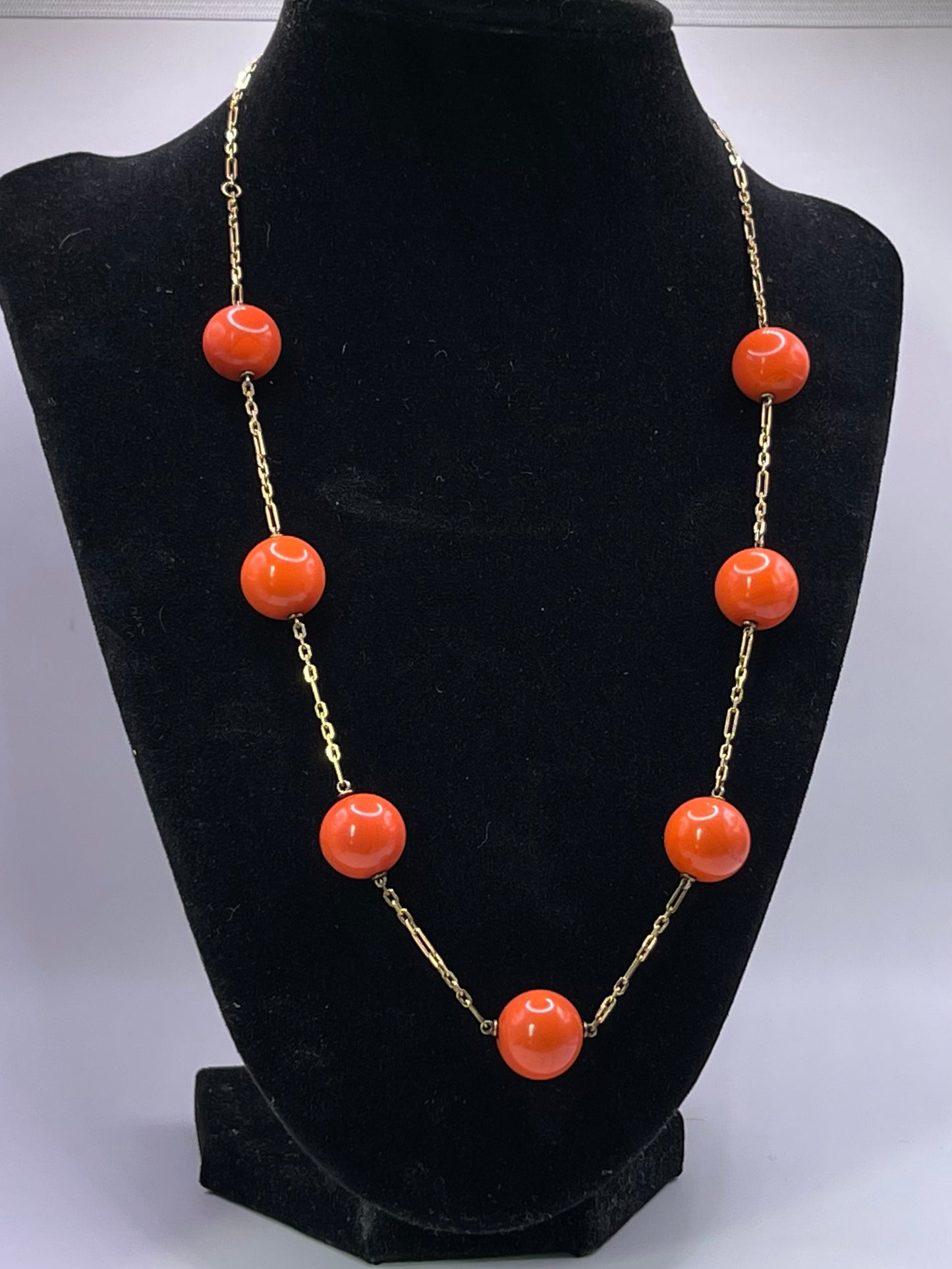 A necklace with coral beads on a 14kt chain