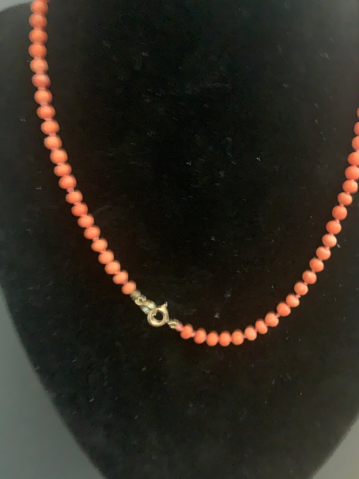 A coral necklace with a carved coral pendant