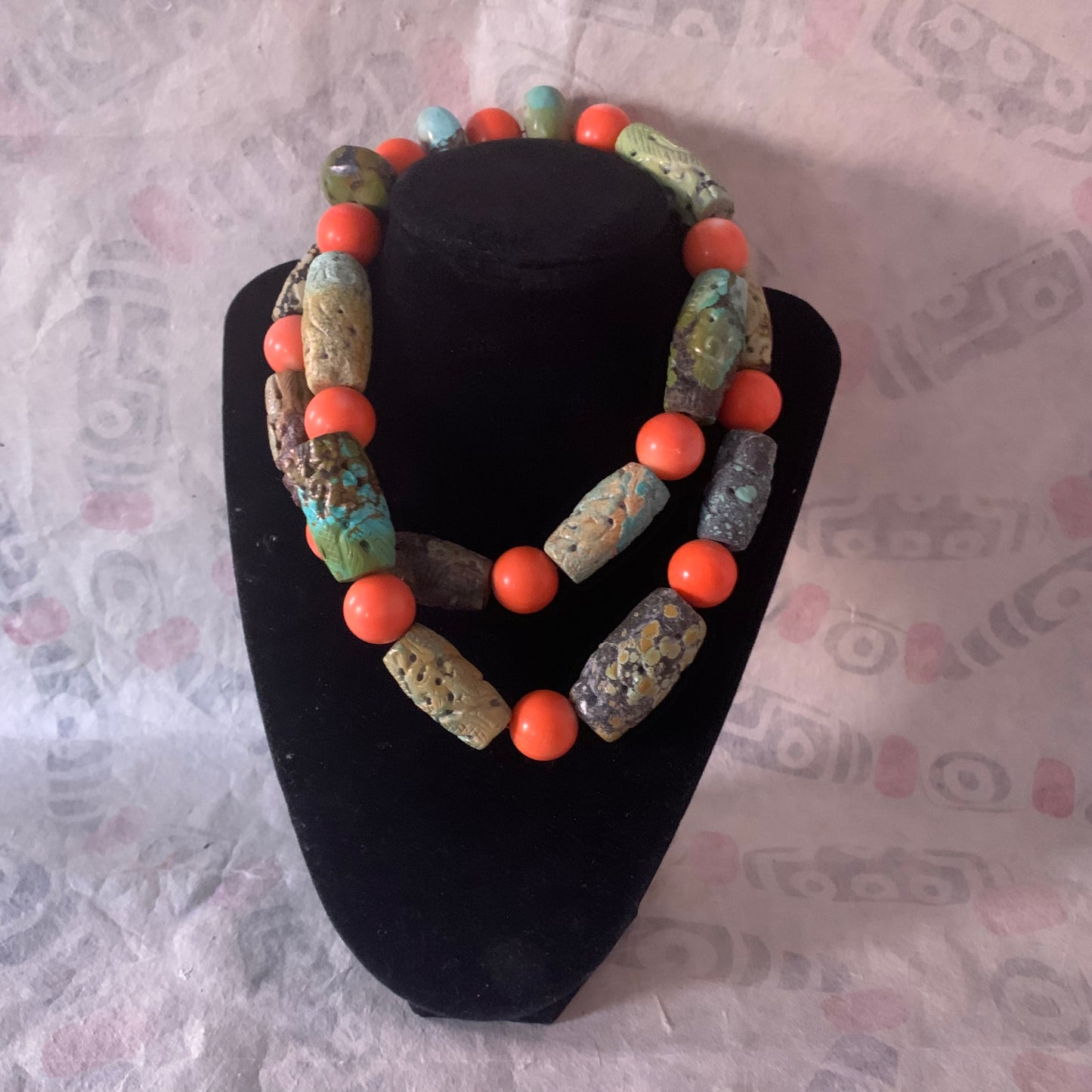 A necklace with antique carved turquoise and vintage coral beads