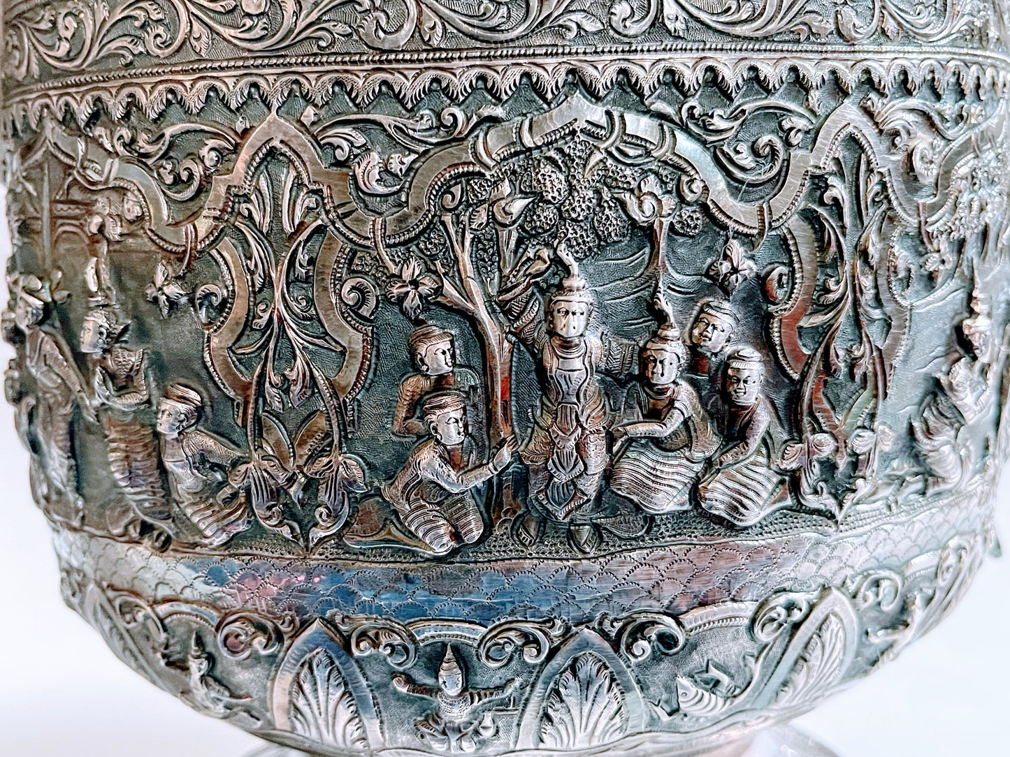 A Burmese antique elaborately carved circular tray and oval shaped jug with a pointed mug.