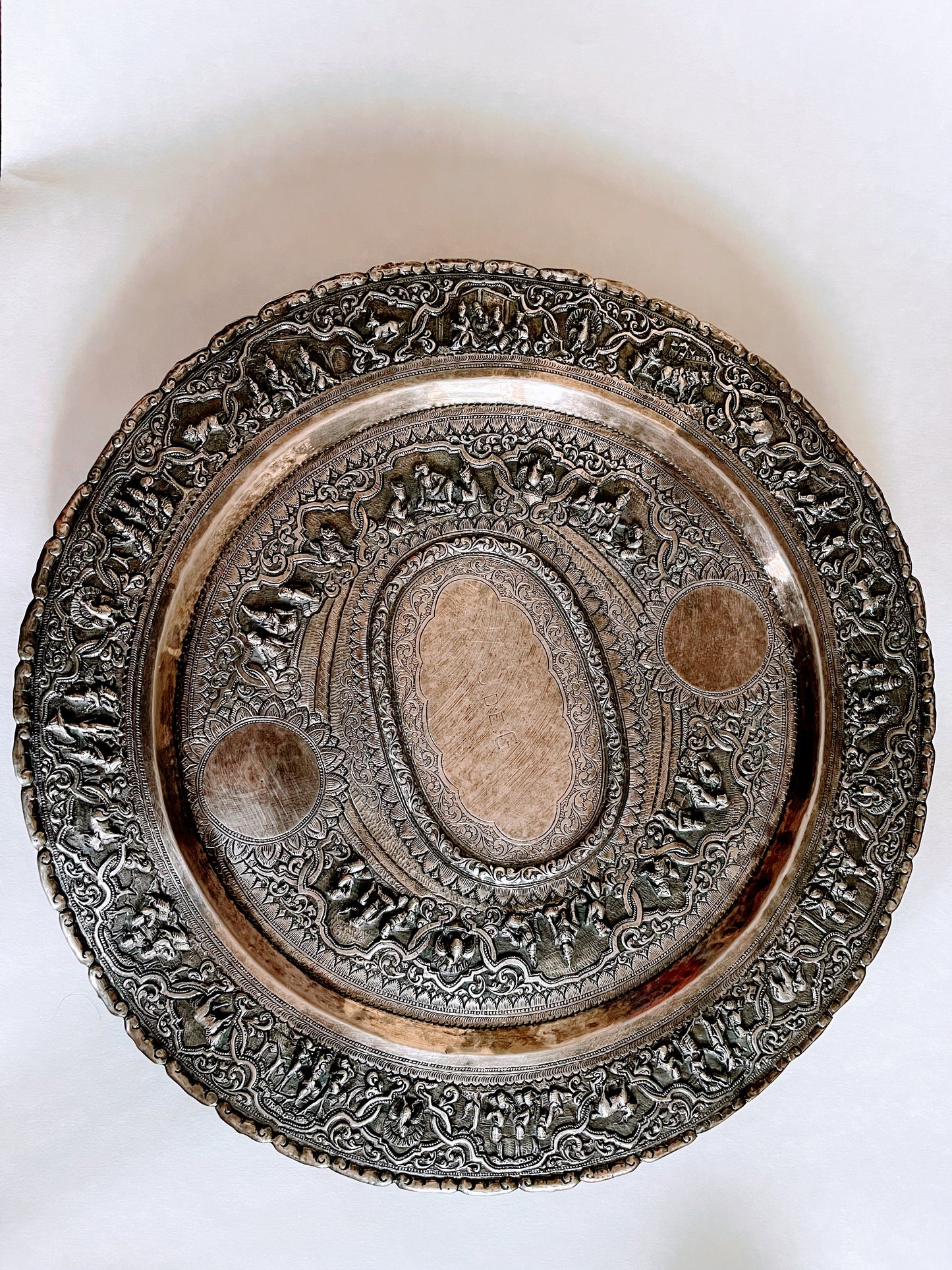 A Burmese antique elaborately carved circular tray and oval shaped jug with a pointed mug.