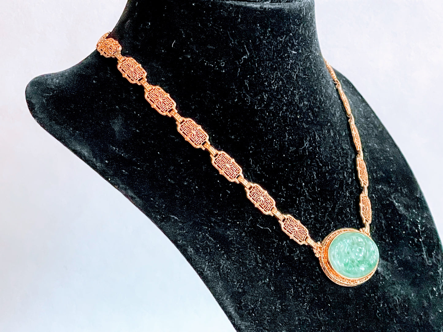 A vintage Art Deco style necklace with a antique apple green jade carved plaque in a 14kt filigree setting