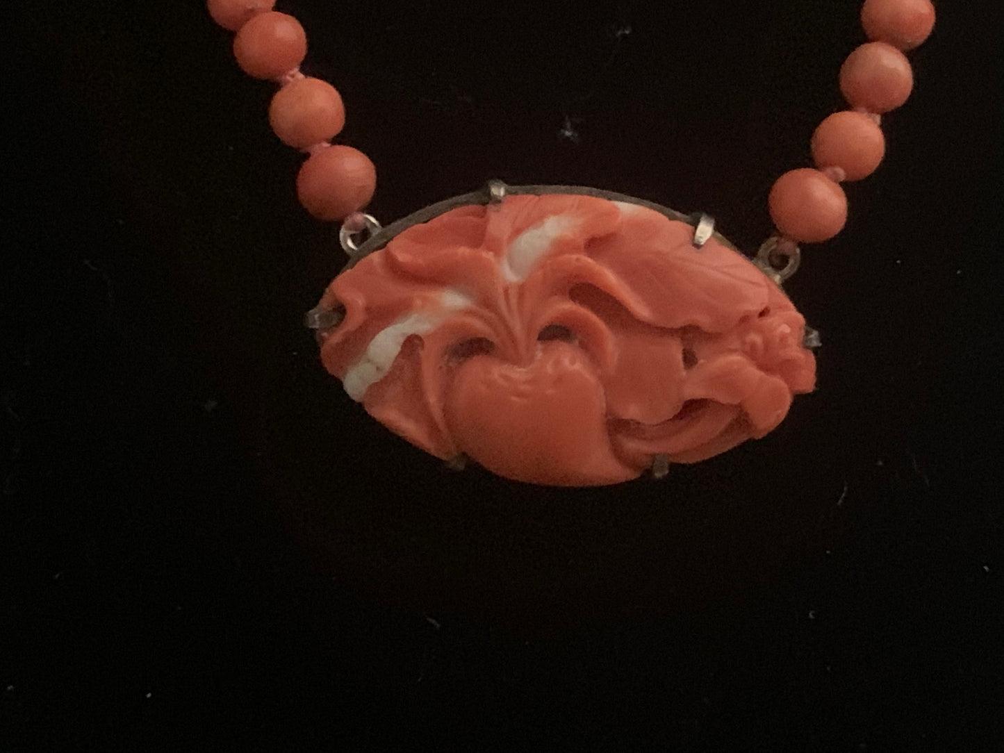 A coral necklace with a carved coral pendant