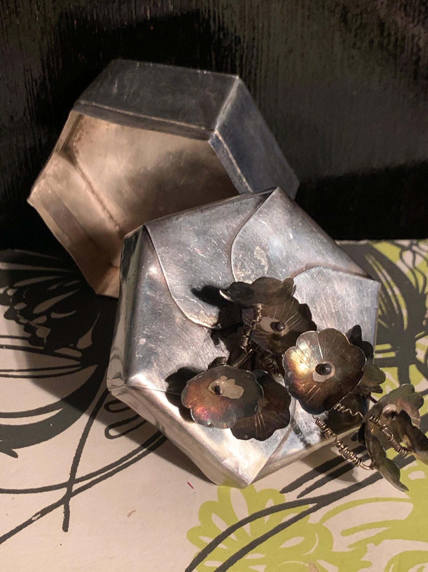 A hexagonal silver box with lid