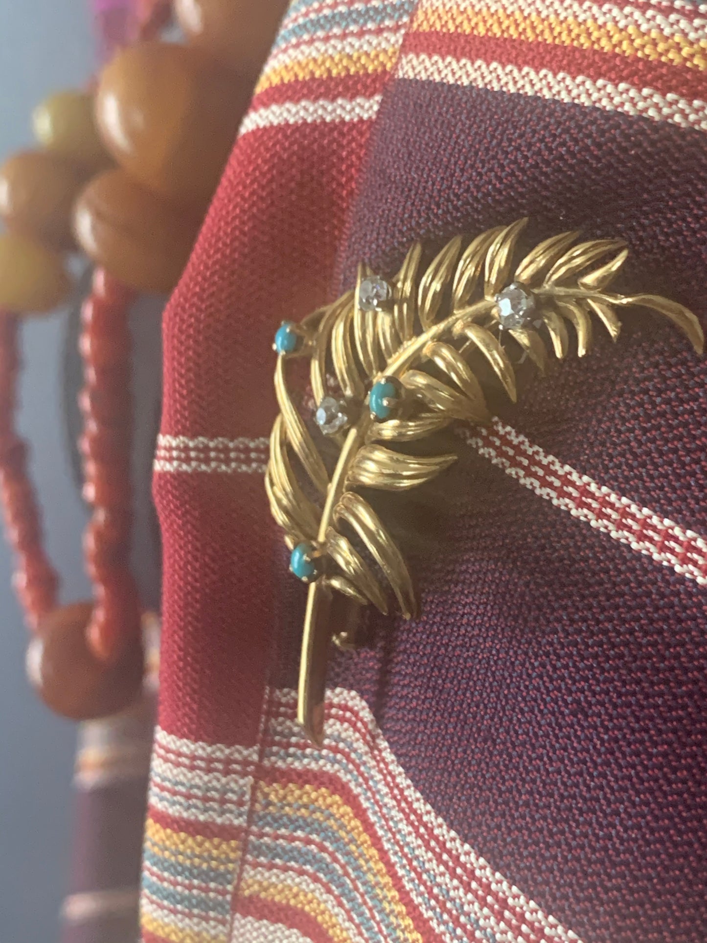 A 18kt gold brooch with turquoise and diamonds.