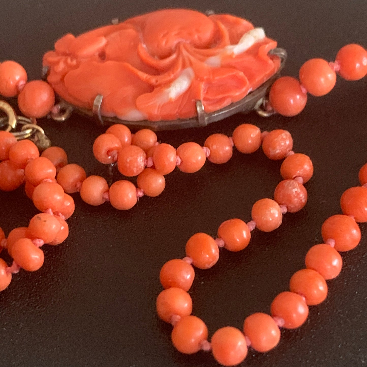 A coral necklace with a carved coral pendant