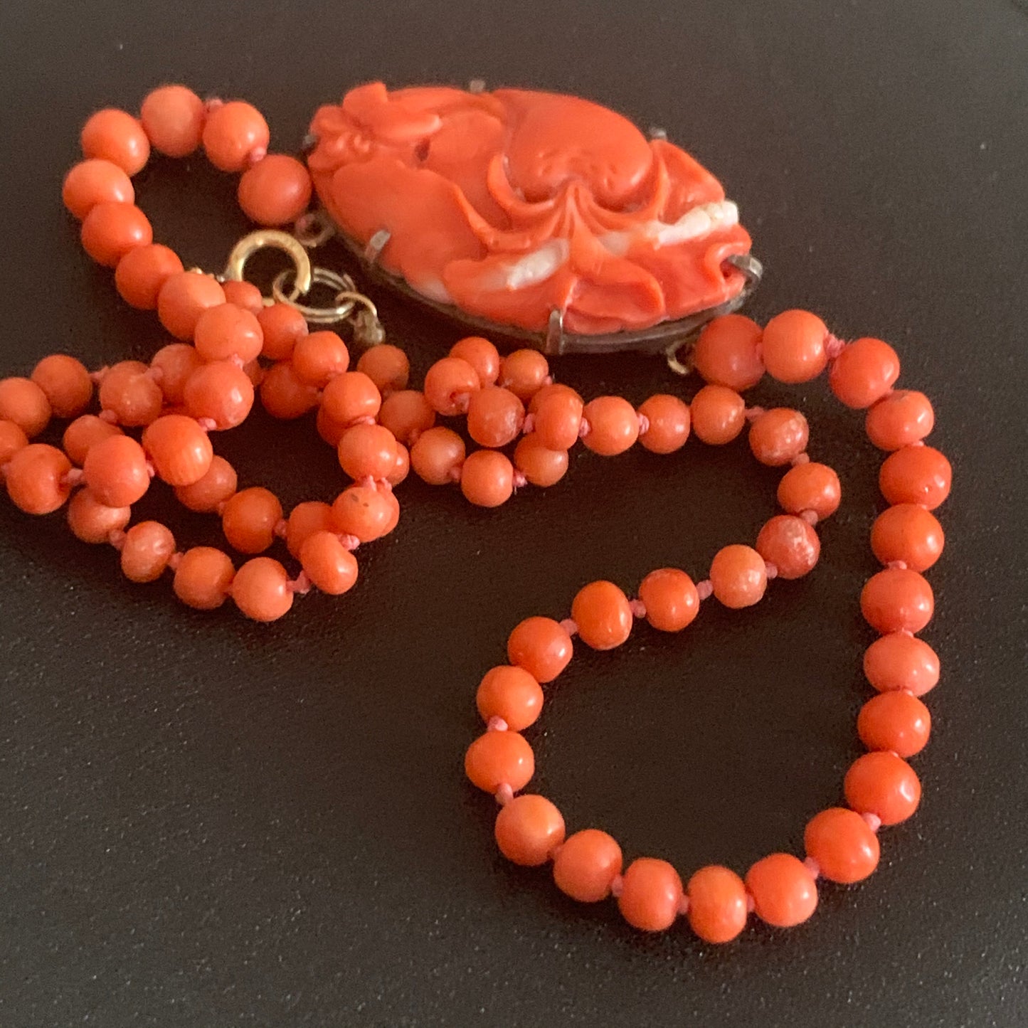 A coral necklace with a carved coral pendant