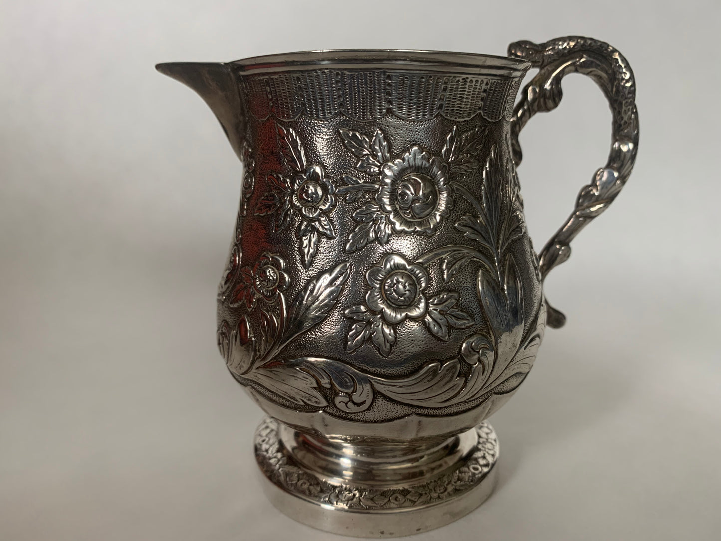 A silver creamer (roses)