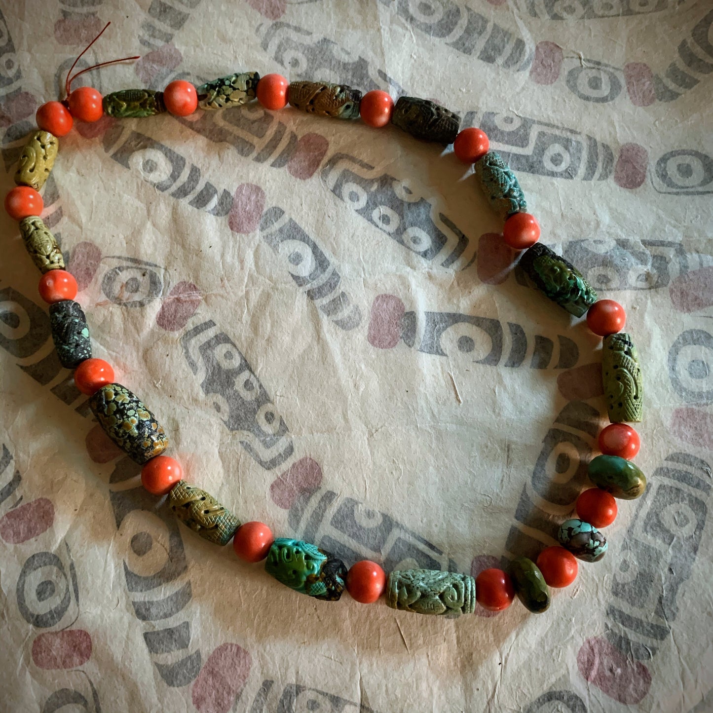 A necklace with antique carved turquoise and vintage coral beads