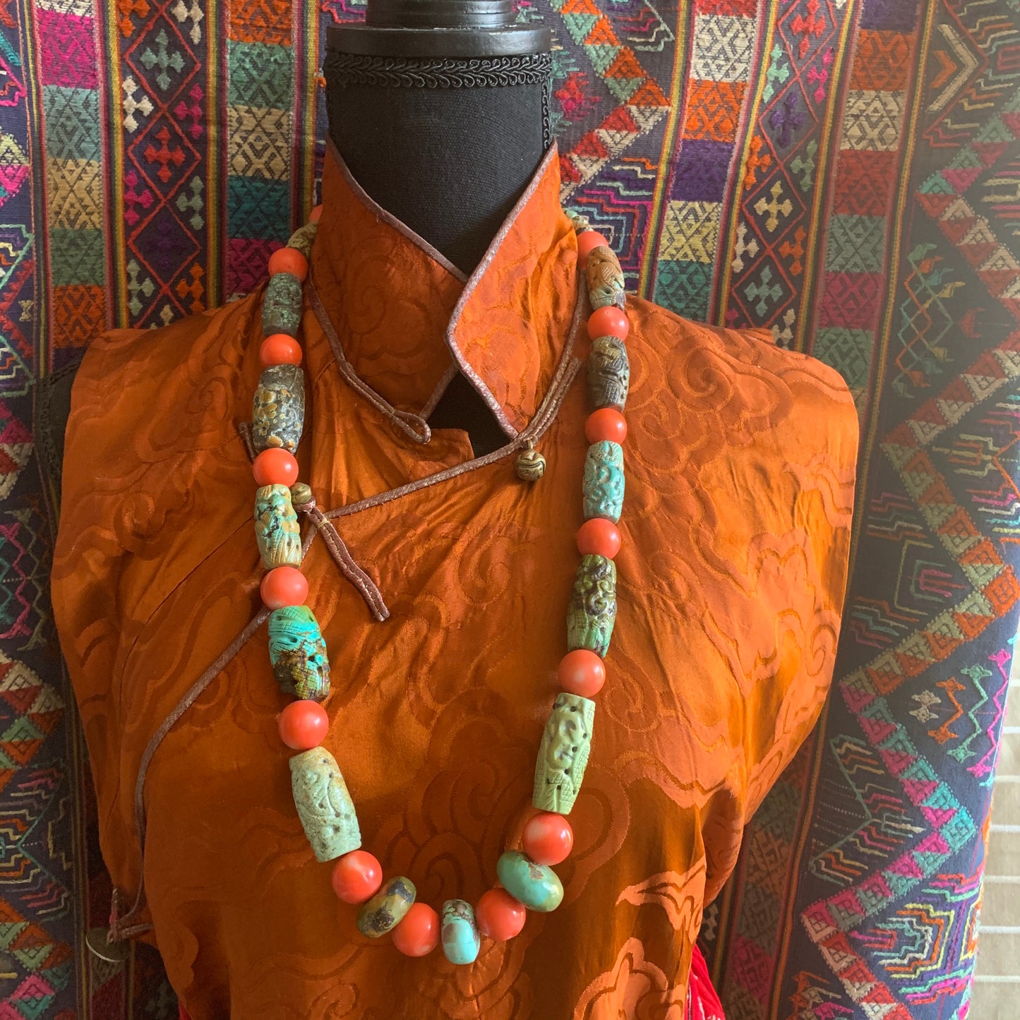 A necklace with antique carved turquoise and vintage coral beads