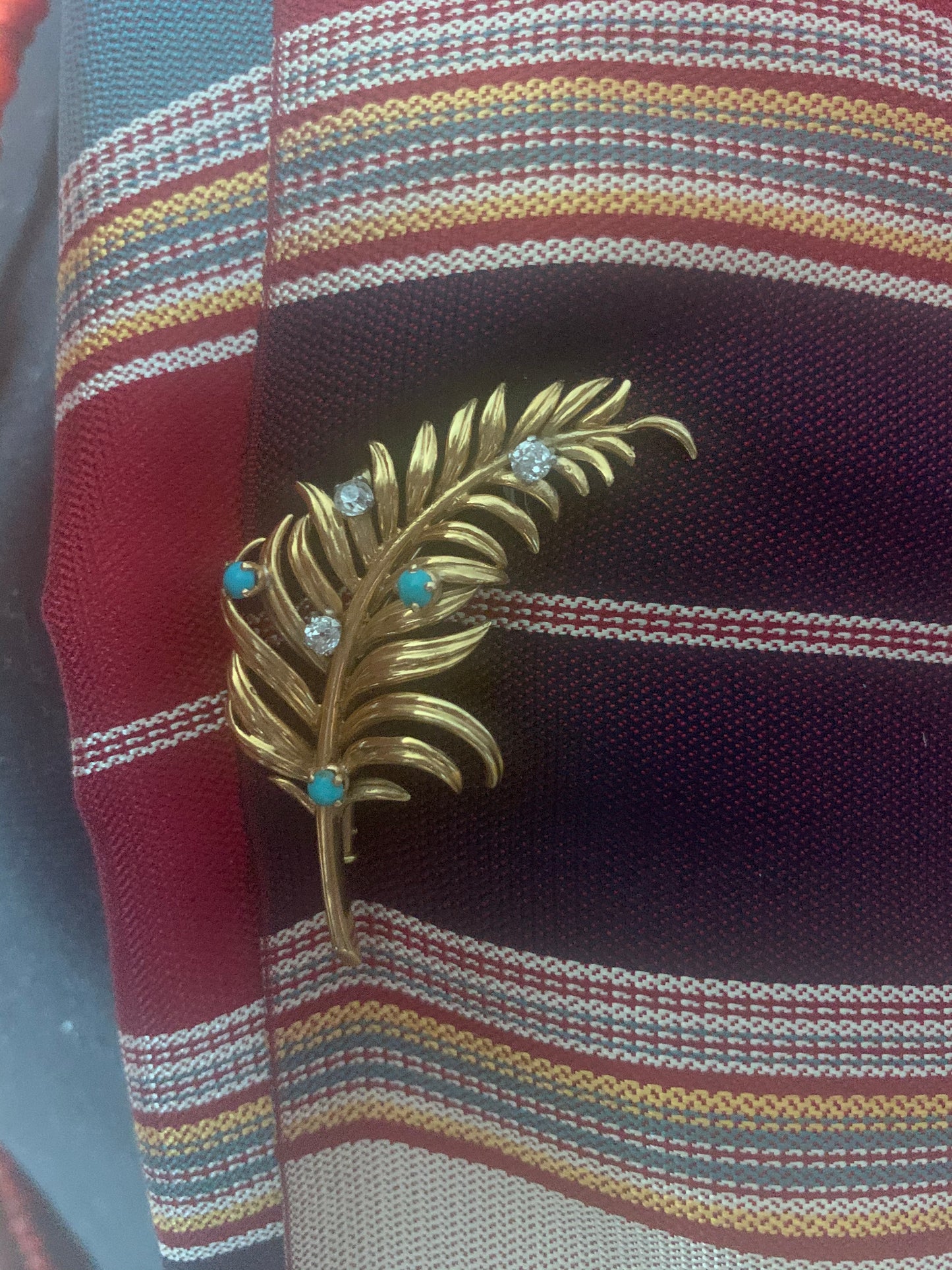 A 18kt gold brooch with turquoise and diamonds.