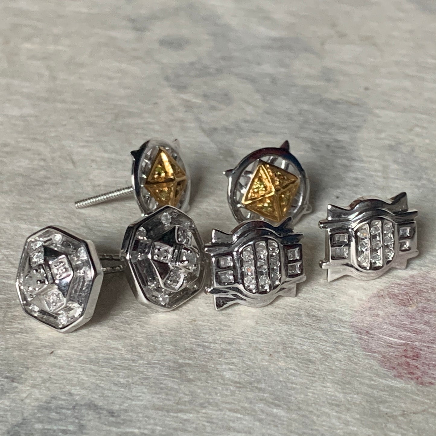 A set of three pairs of diamond ear studs in 10kt settings