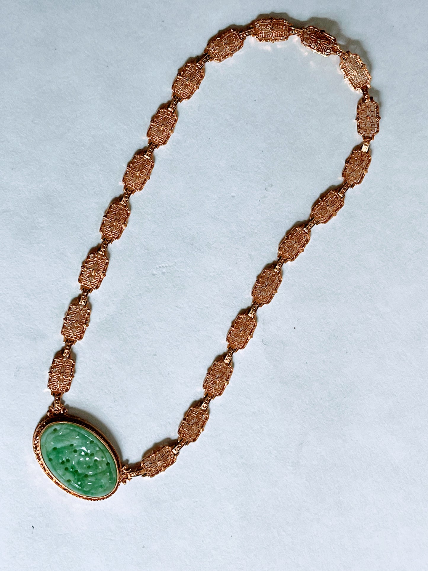 A vintage Art Deco style necklace with a antique apple green jade carved plaque in a 14kt filigree setting